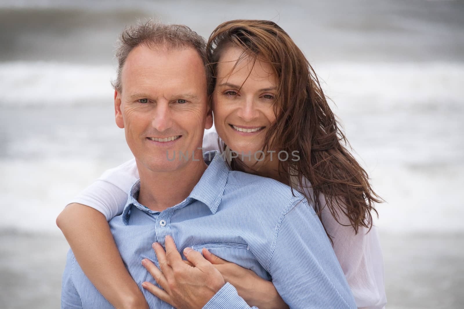 happy adult couple in summertime on beach having fun vacation