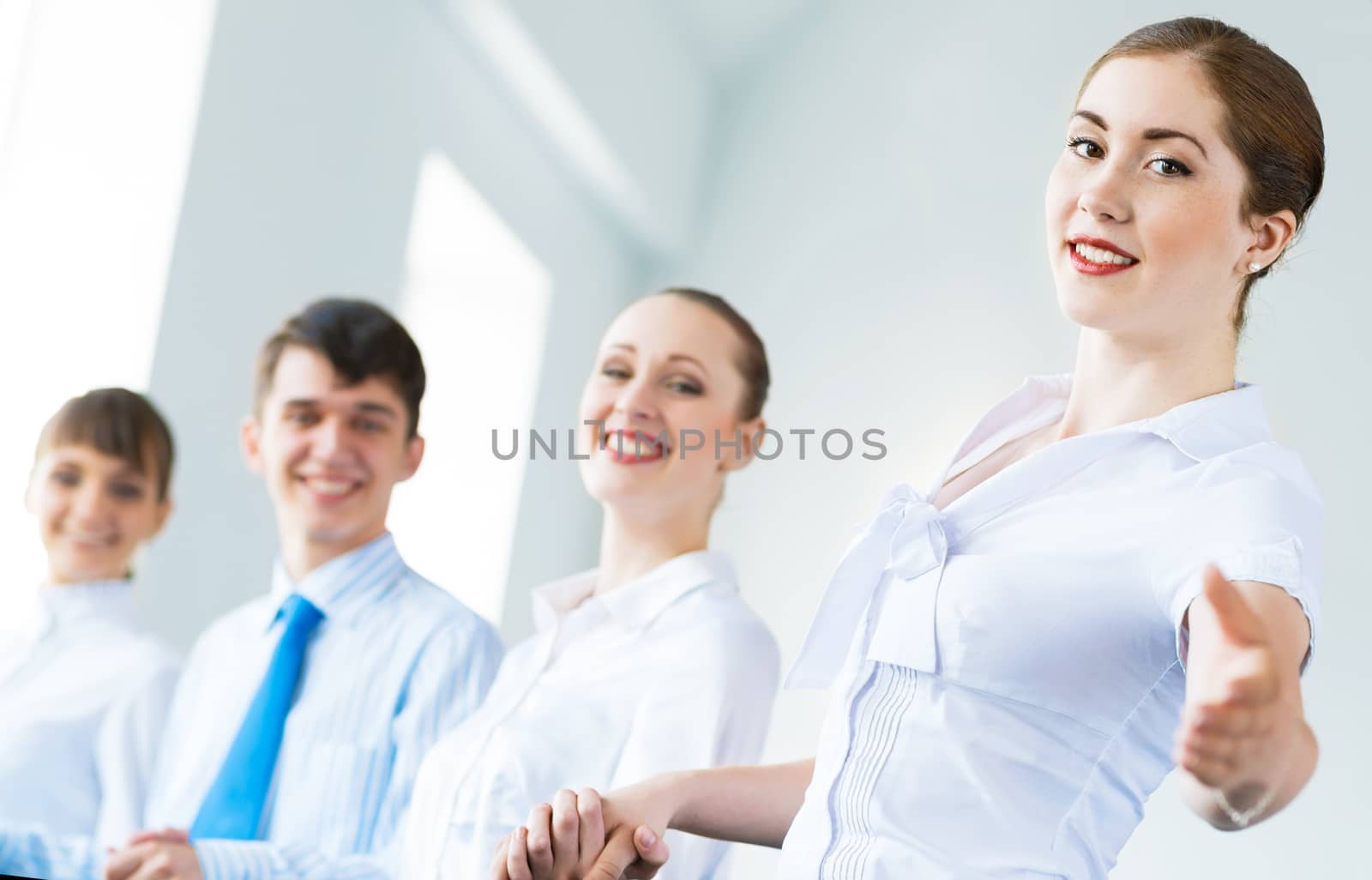 invitation to the team, business woman holds out her hand, her face a number of young businessmen