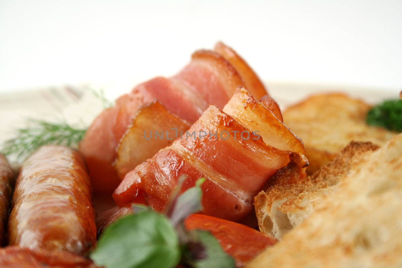 Crispy rolled bacon with toast tomato and sausages.