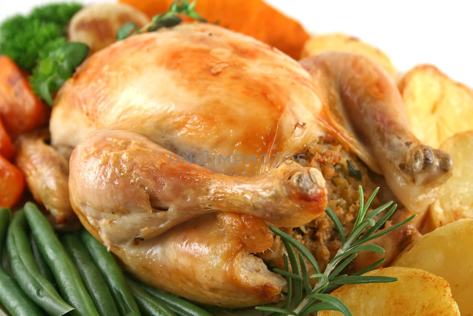 Whole roast chicken with potatoes pumpkin carrots and beans.