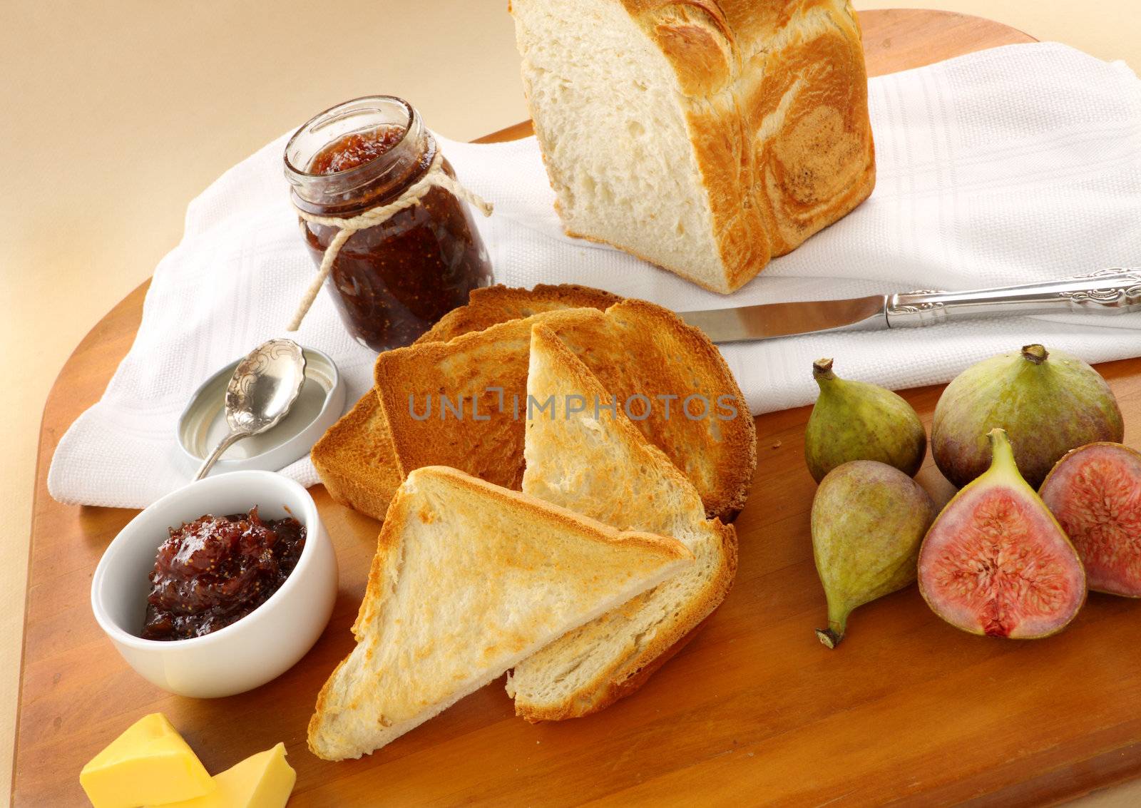 Homemade fig jam with crusty bread, toast and fresh figs.