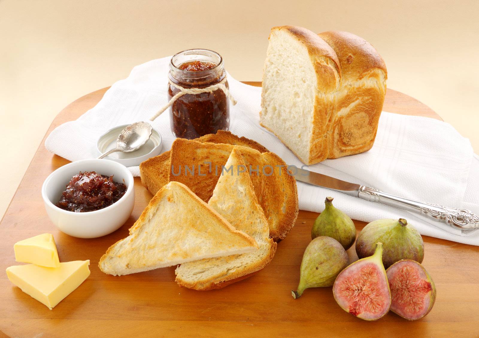 Homemade fig jam with crusty bread, toast and fresh figs.