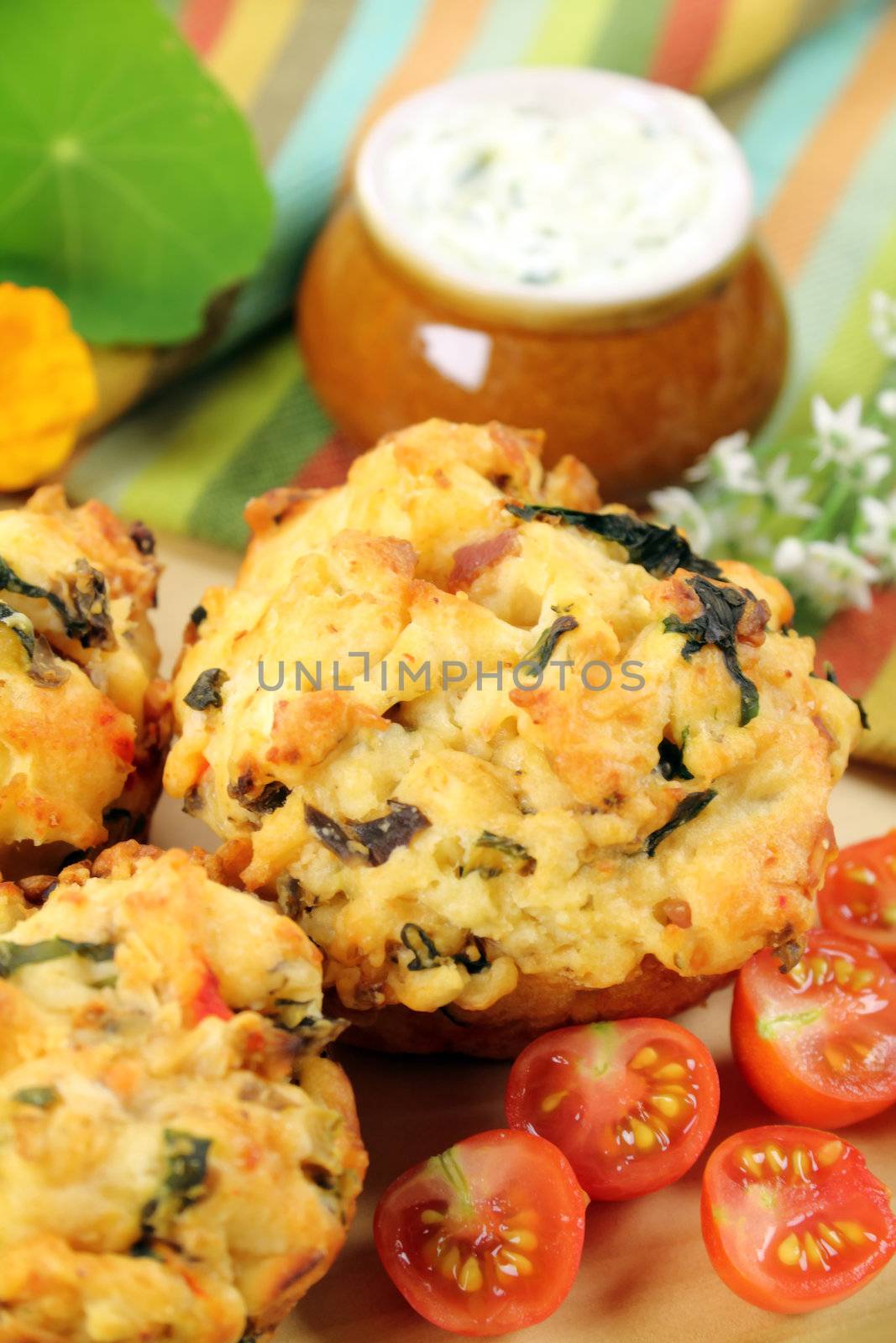 Fresh baked savory muffins with herb spread and cherry tomatoes.