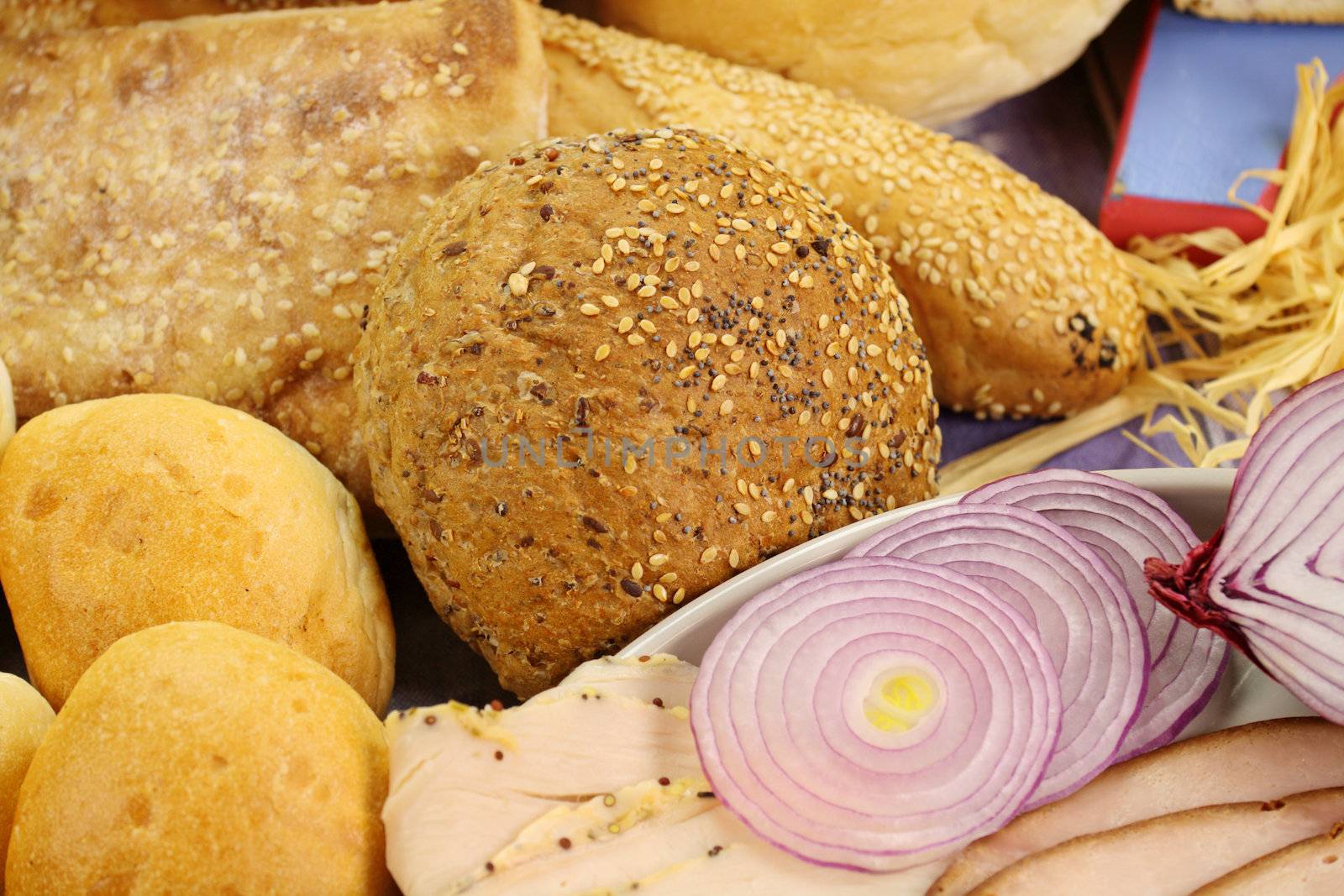 Selection of breads and rolls with cold cuts and salad.