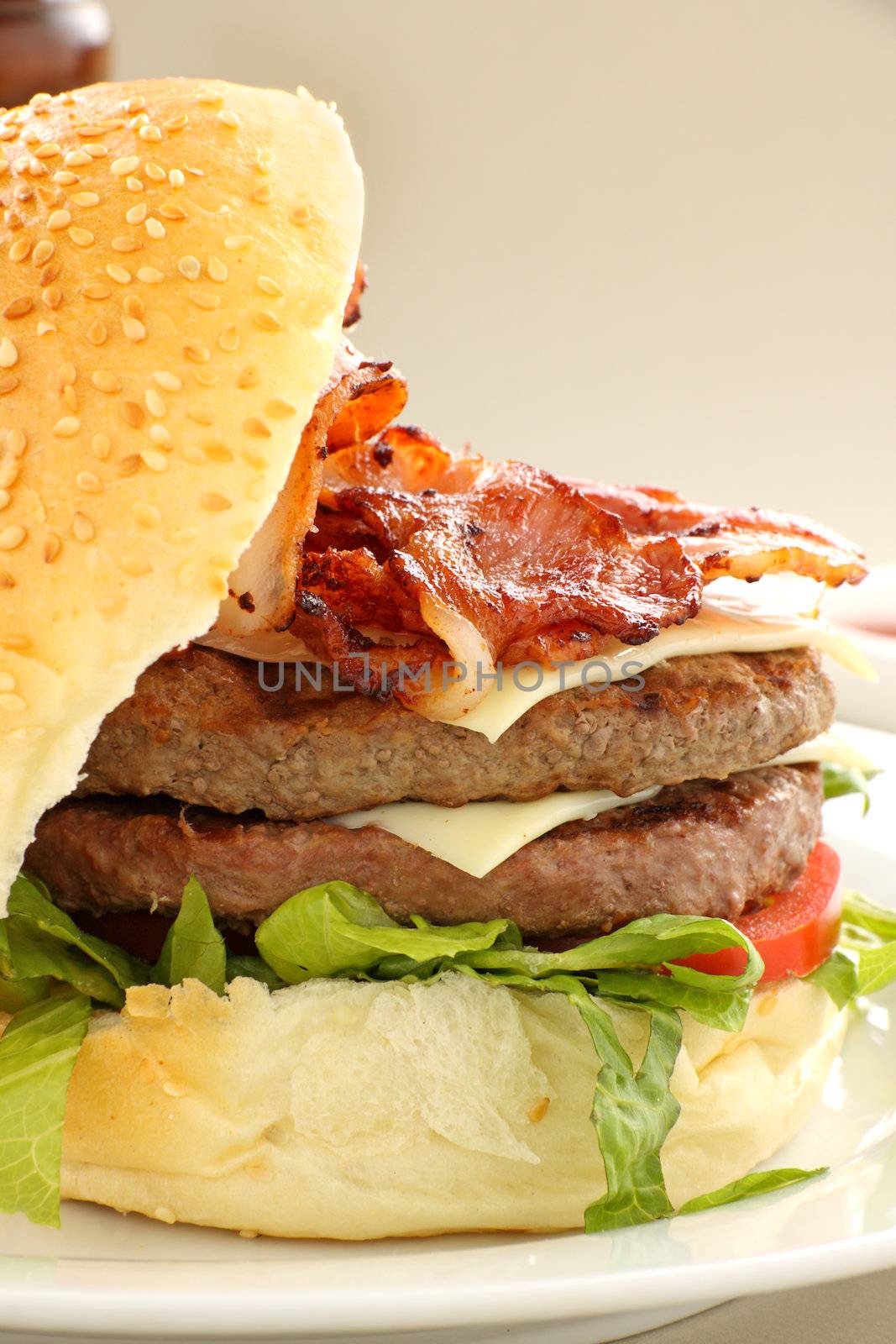 Double decker hamburger with bacon and cheese ready to serve.