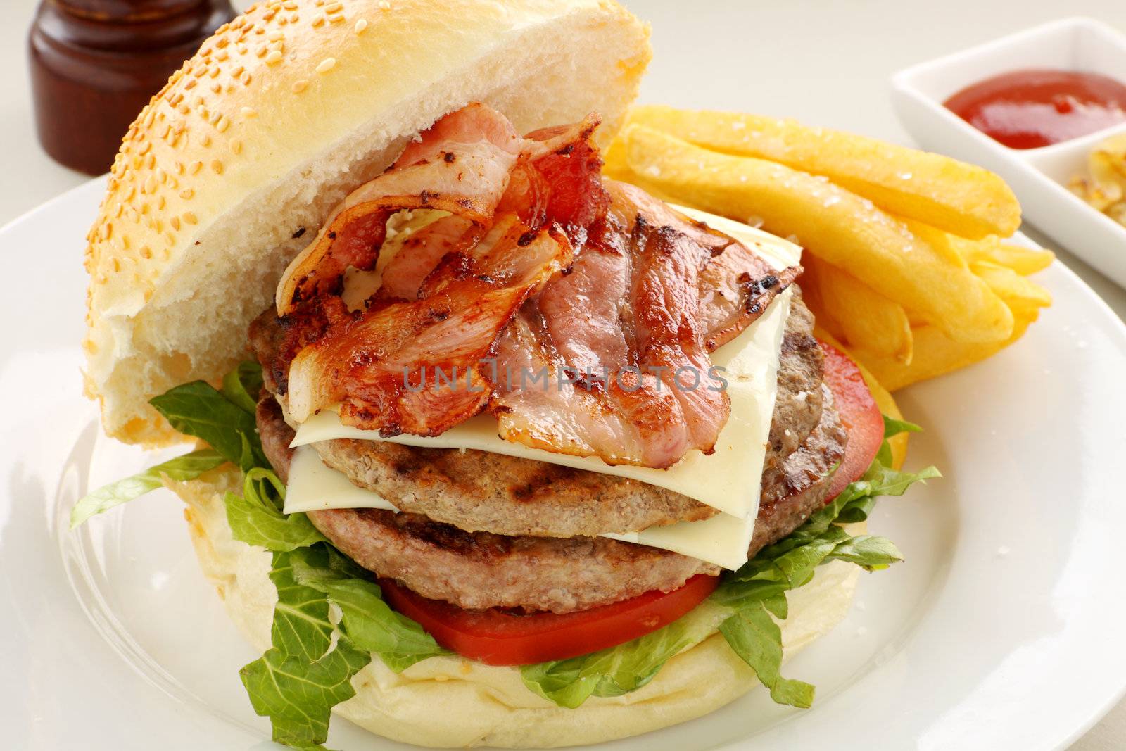 Double decker hamburger with bacon and cheese ready to serve.