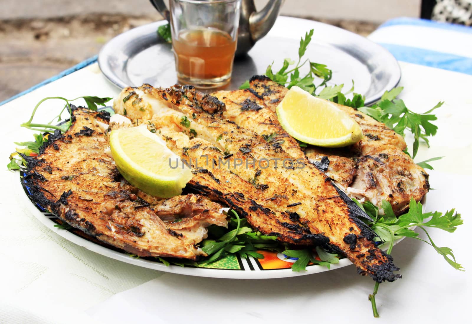 Grilled fish with greens on the plate
