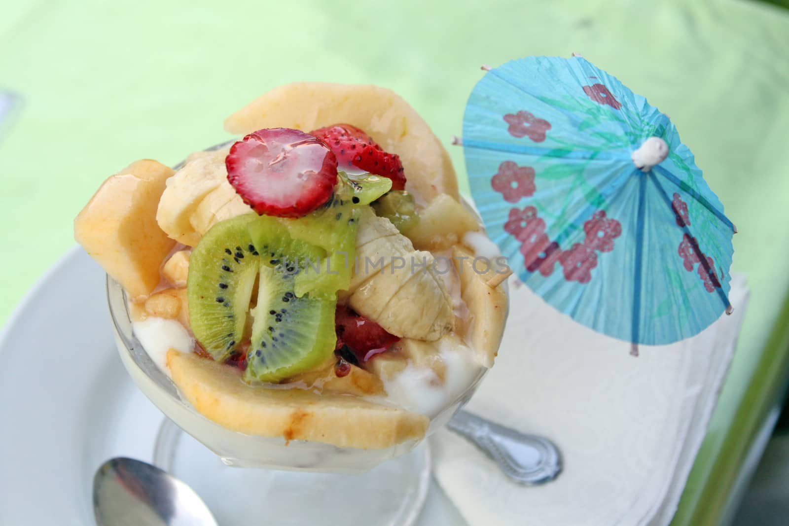 Fruit salad with kiwi, strawberries, bananas, other fruits and yogurt
