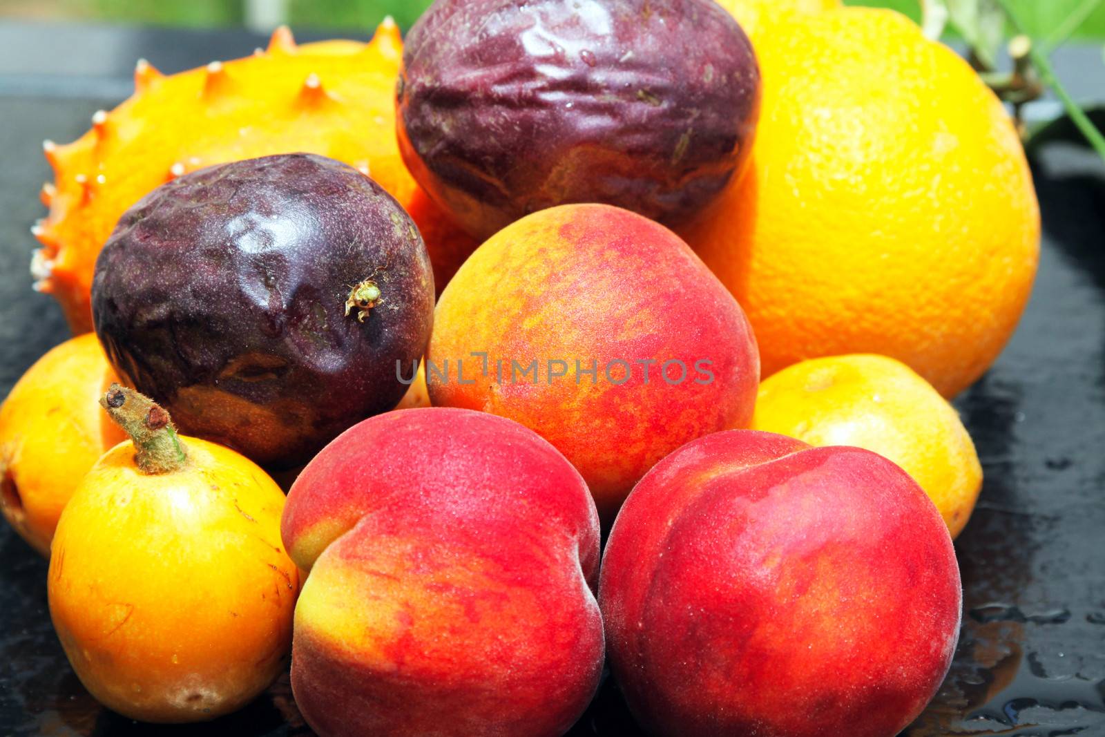 Exotic fruits: orange, kiwano, loquat, peach and passionfruit