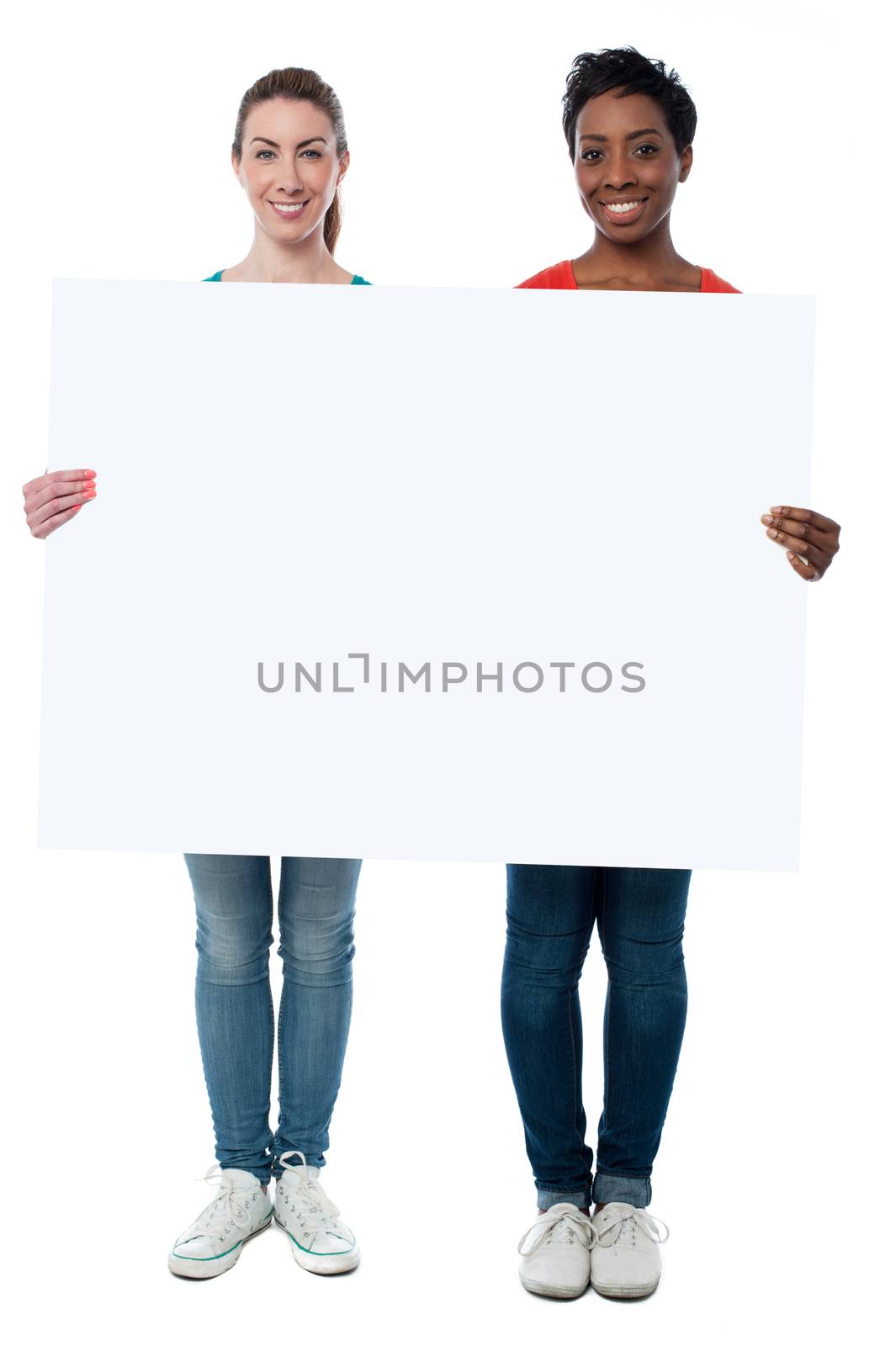 Casual women holding blank whiteboard by stockyimages