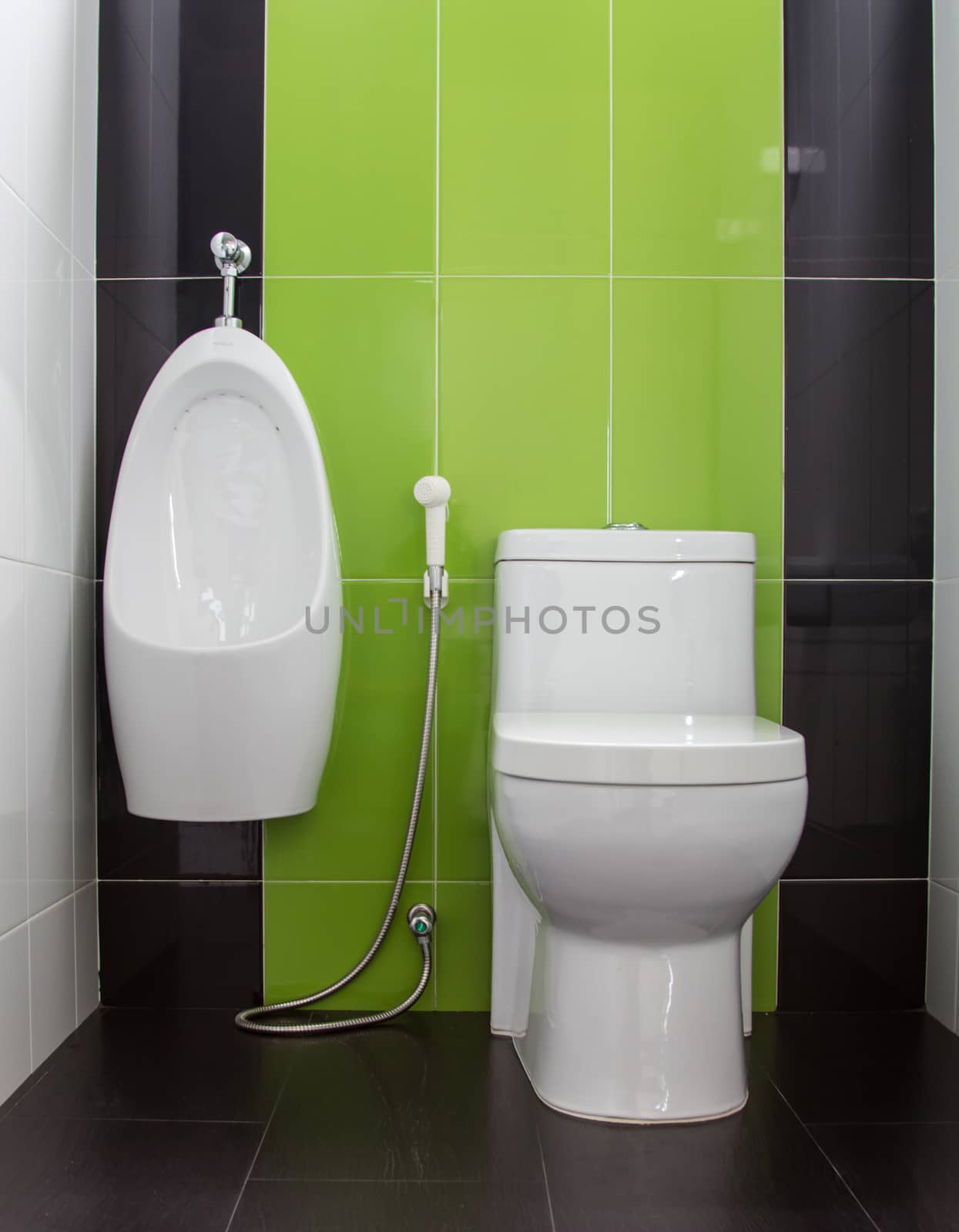 Toilet in gray and green tiled bathroom