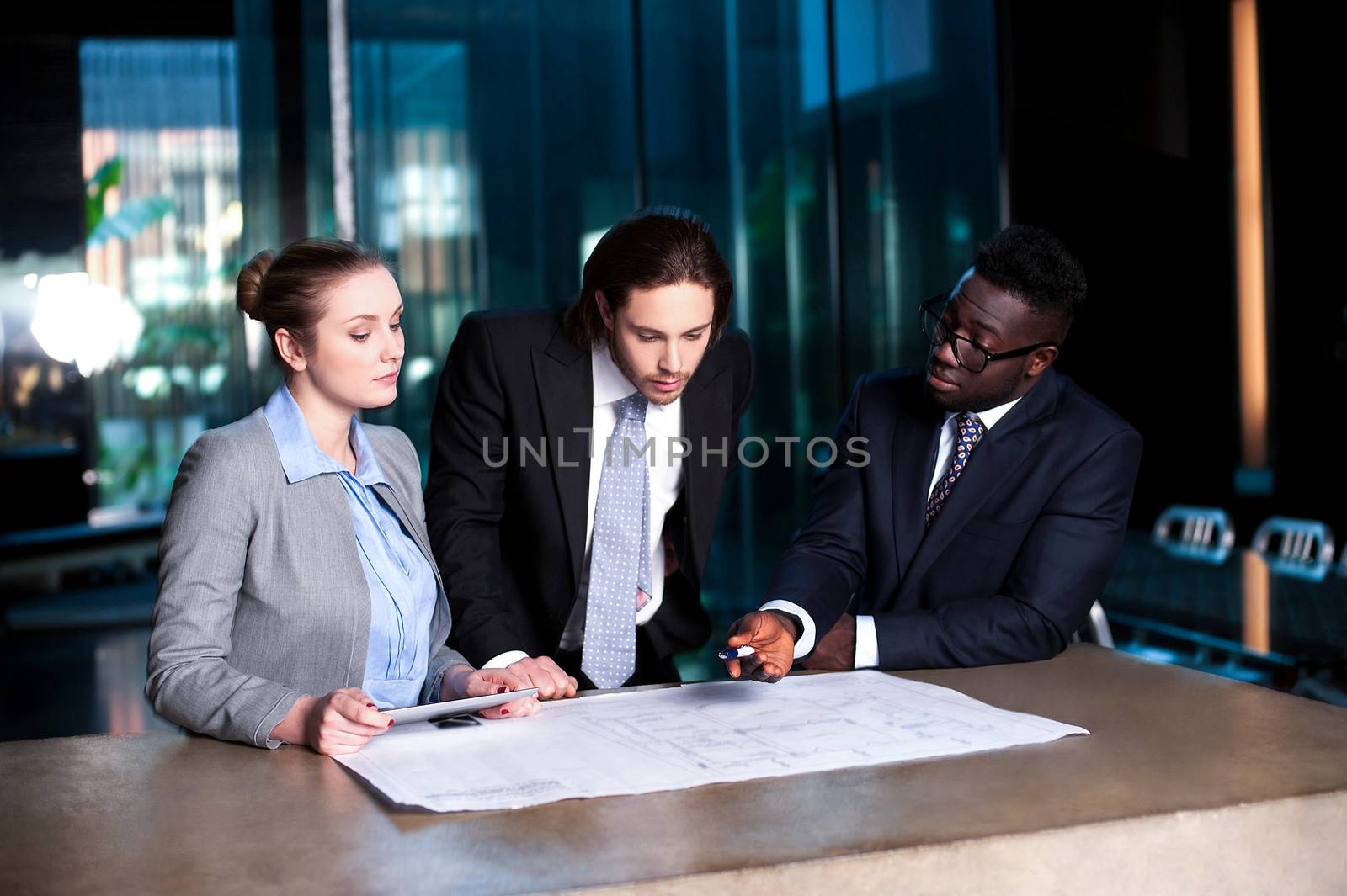 Business team of three reviewing project plan by stockyimages