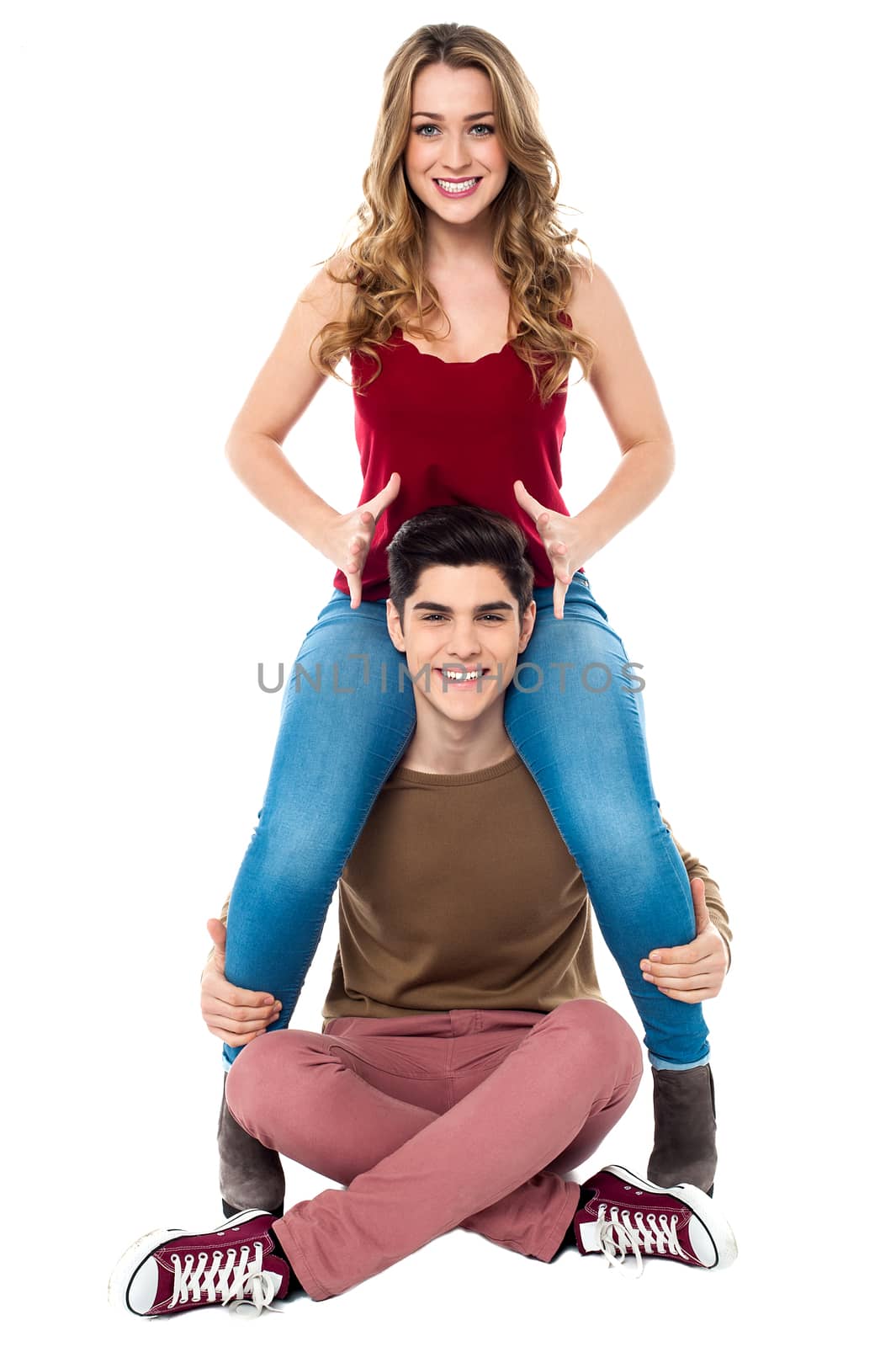Girl sitting on boyfriend's shoulder, studio shot