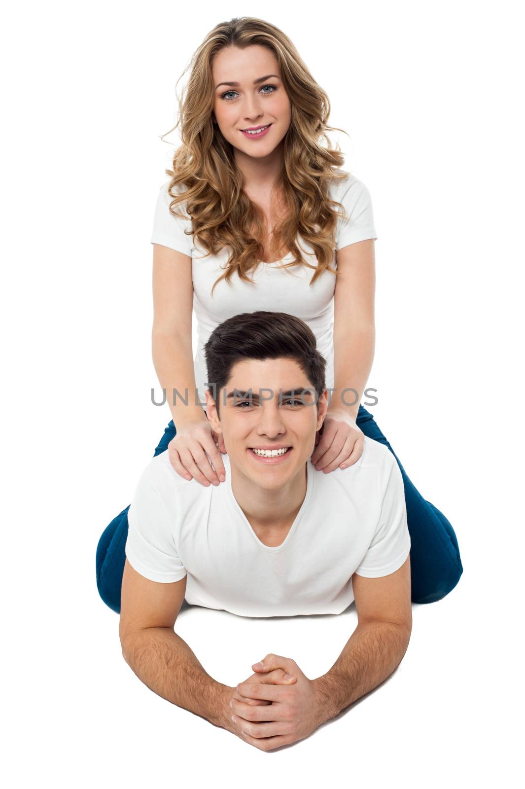 Pretty girl riding on her boyfriend's back by stockyimages
