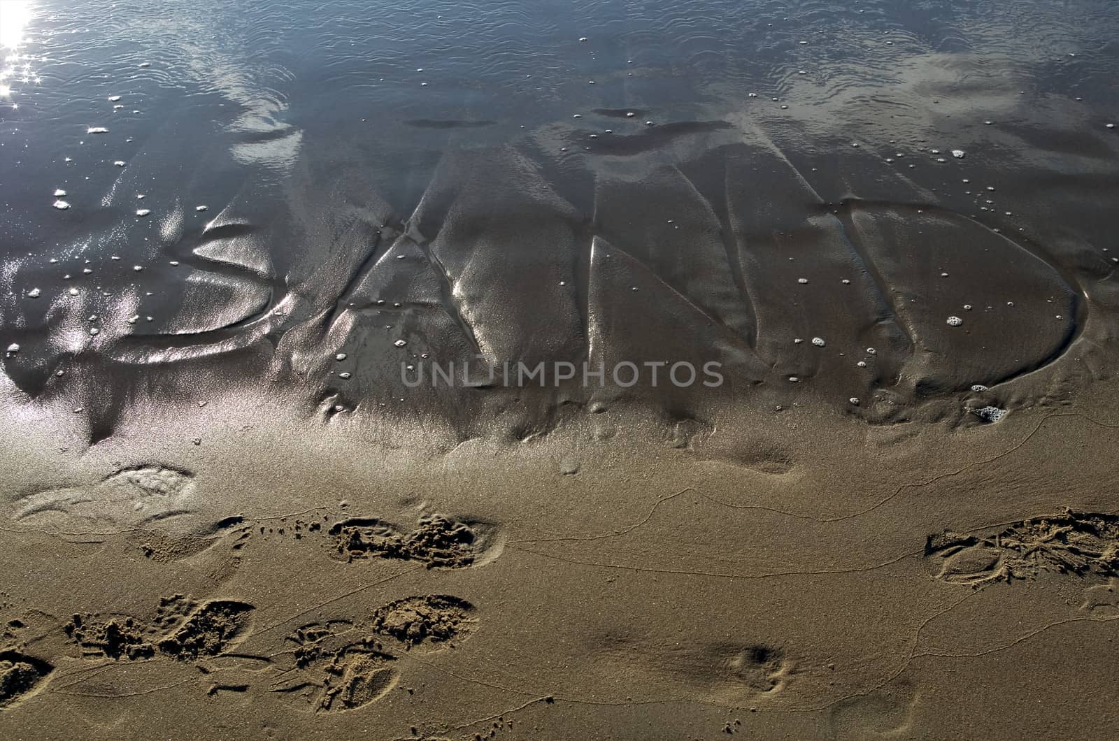Sand writing loses its battle with the sea and is washed away