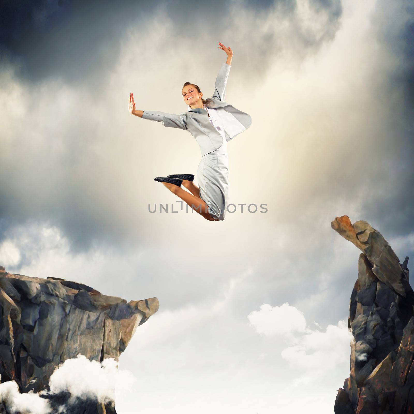 Image of young businesswoman jumping over gap