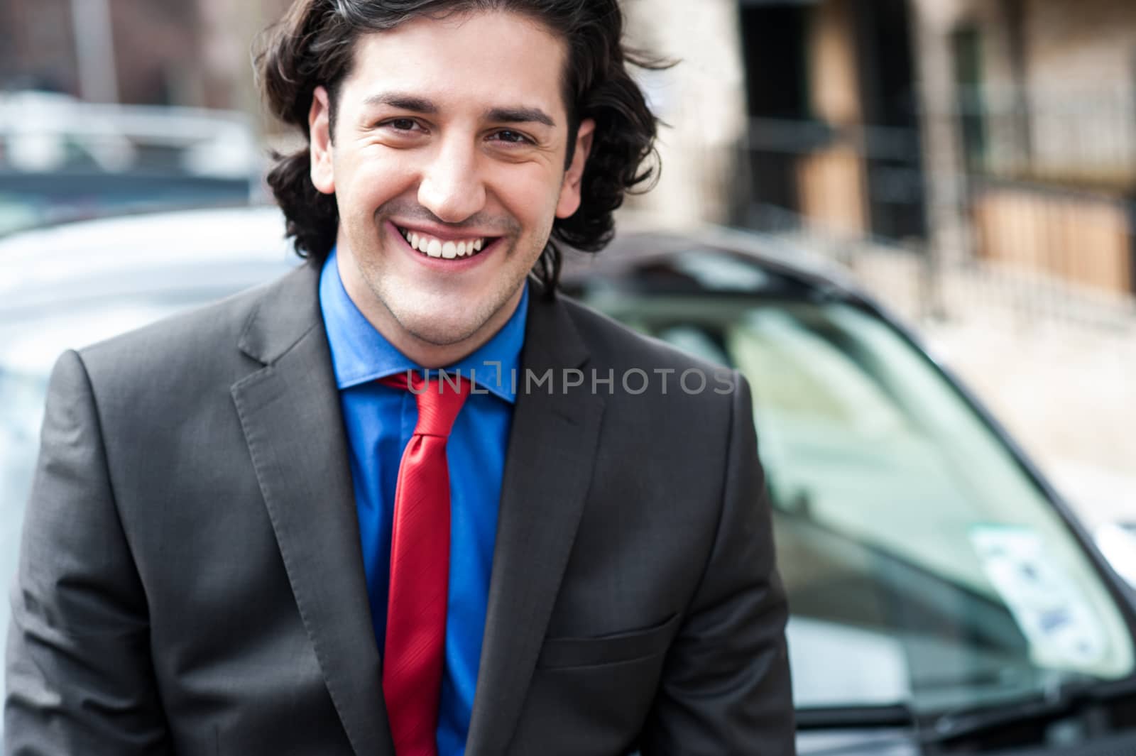 Handsome smiling businessman posing outdoors