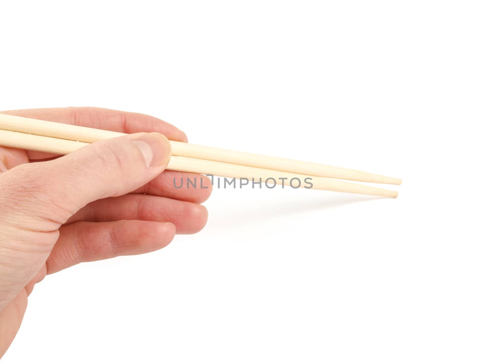 Person holding a pair of wooden chopsticks towards white background