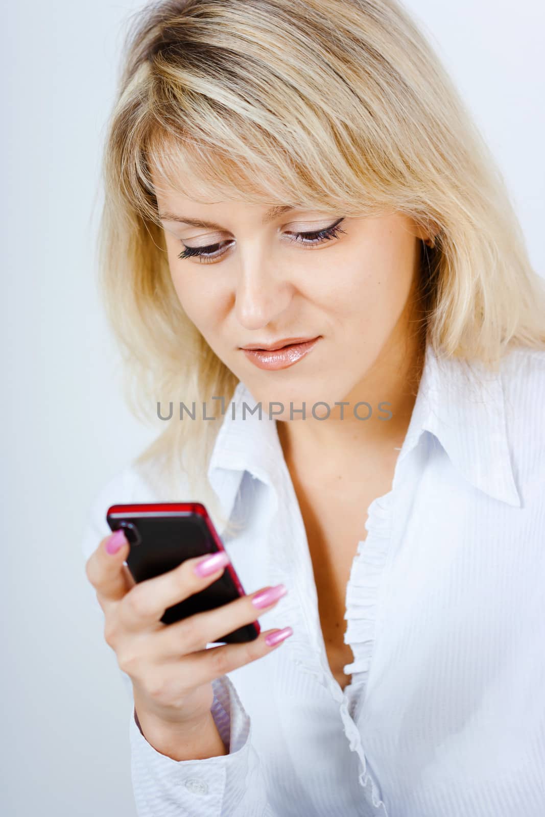 portrait of blonde girl with mobile phone in hand