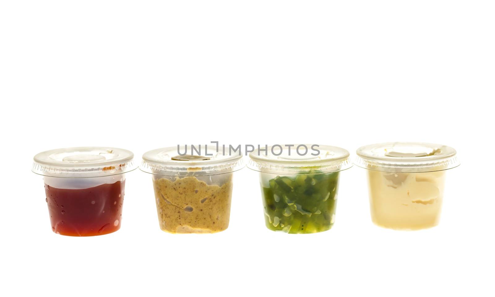 Relish mustard ketchup and mayonnaise condiments in clear containers on white background