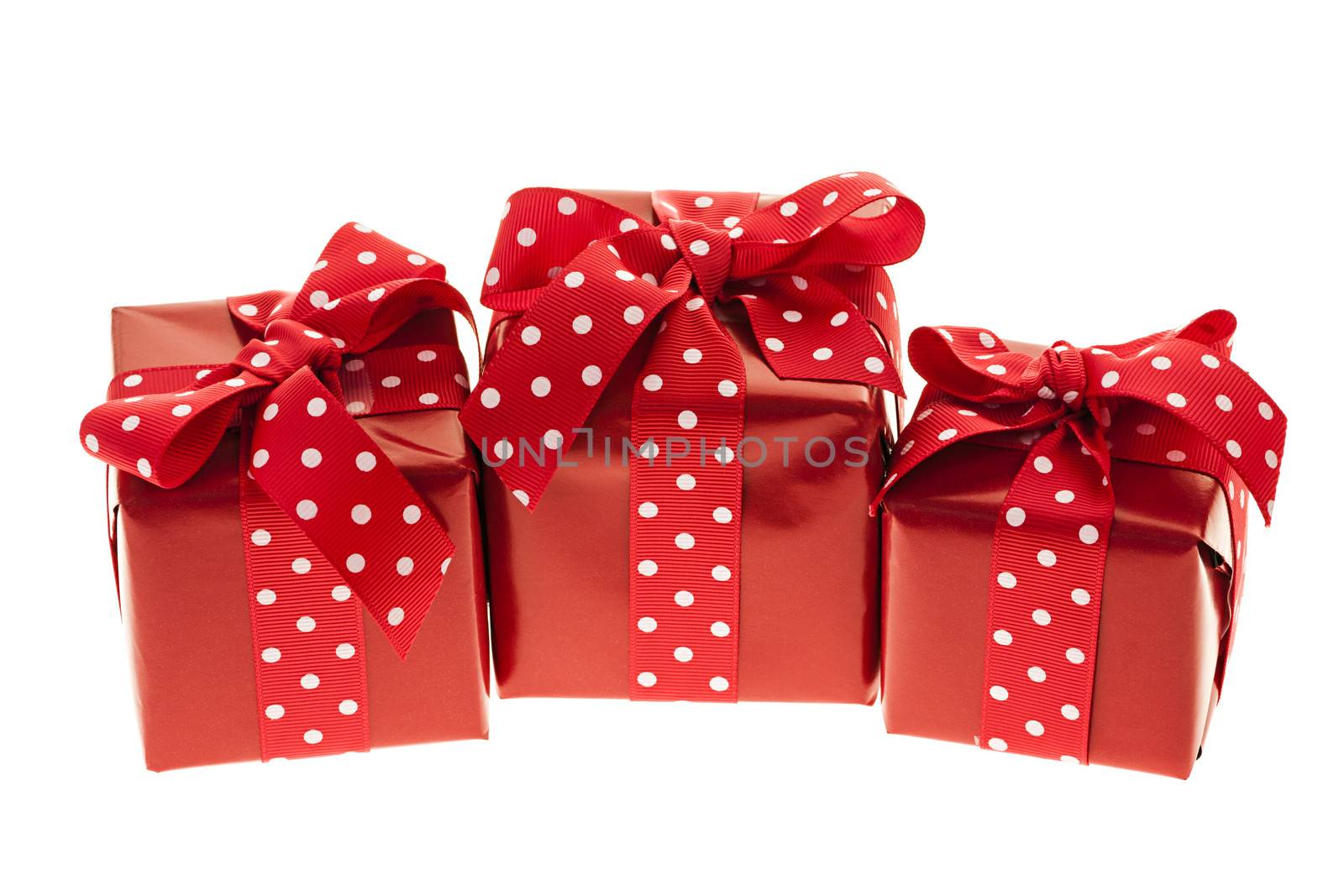 Three presents wrapped in red paper with polkadot ribbon