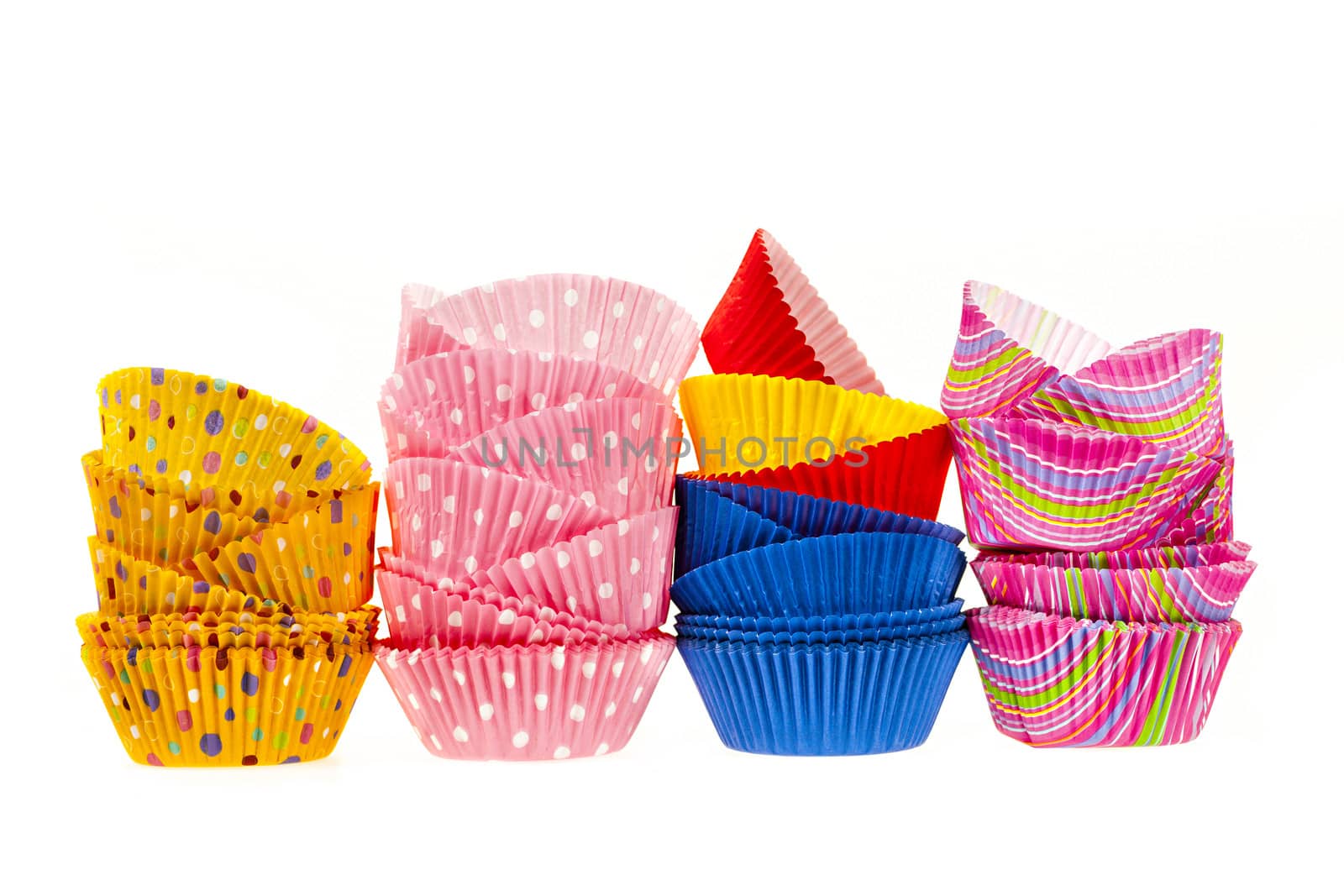 Several stacks of colorful muffin or cupcake cups isolated on white background