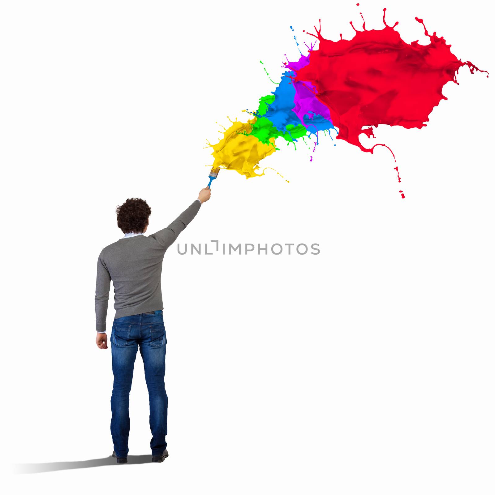 Young man spraying colour paints over background