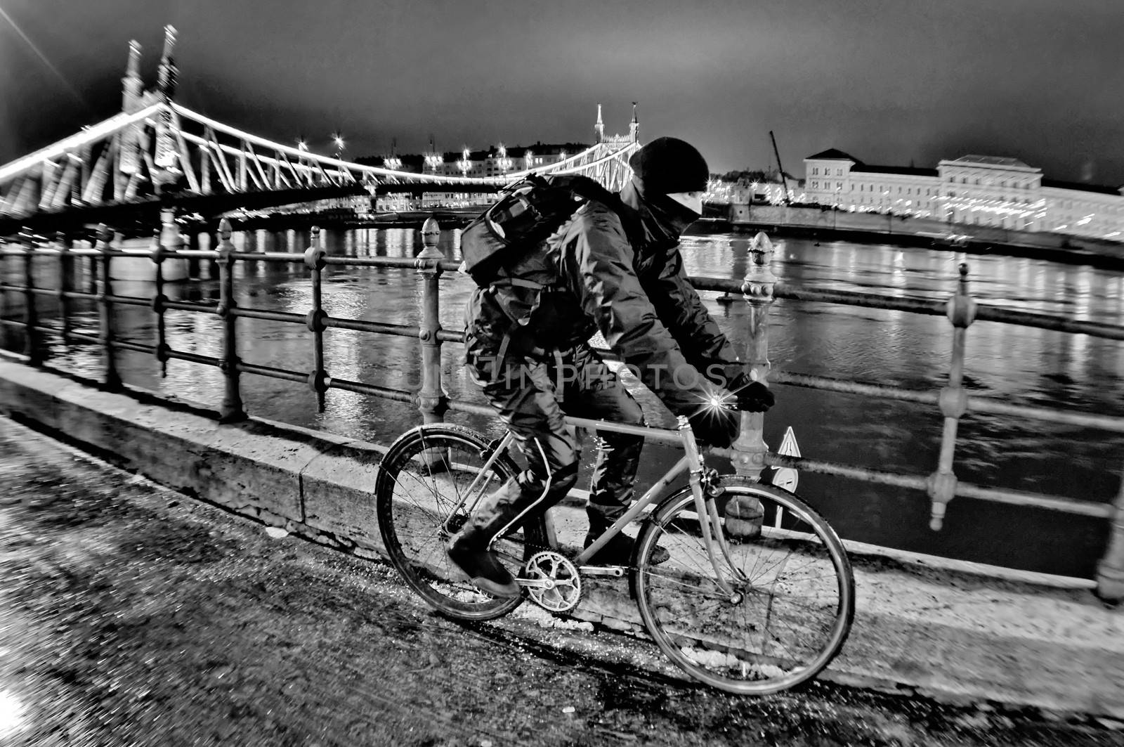 Cyclist moving next to river Danube at night