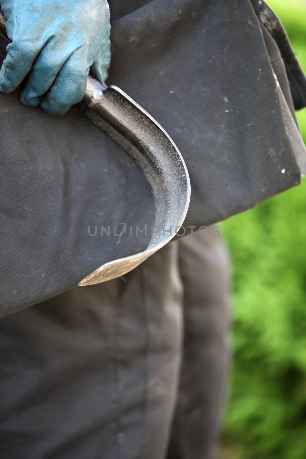 Curved scraping tool for cleaning a chimney flue of soot and debris from a domestic fire in the gloved hand of a chimney sweep