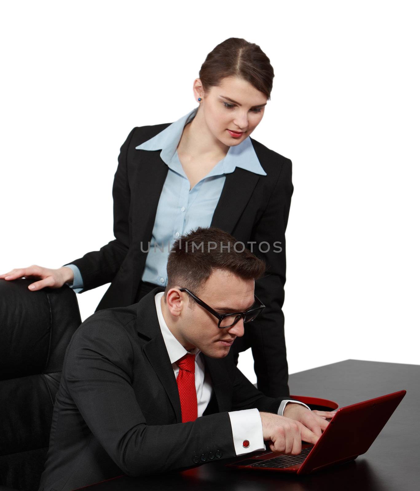 Young businesscouple looking together to a notebook, isolated against a white background. Selective focus on the man.