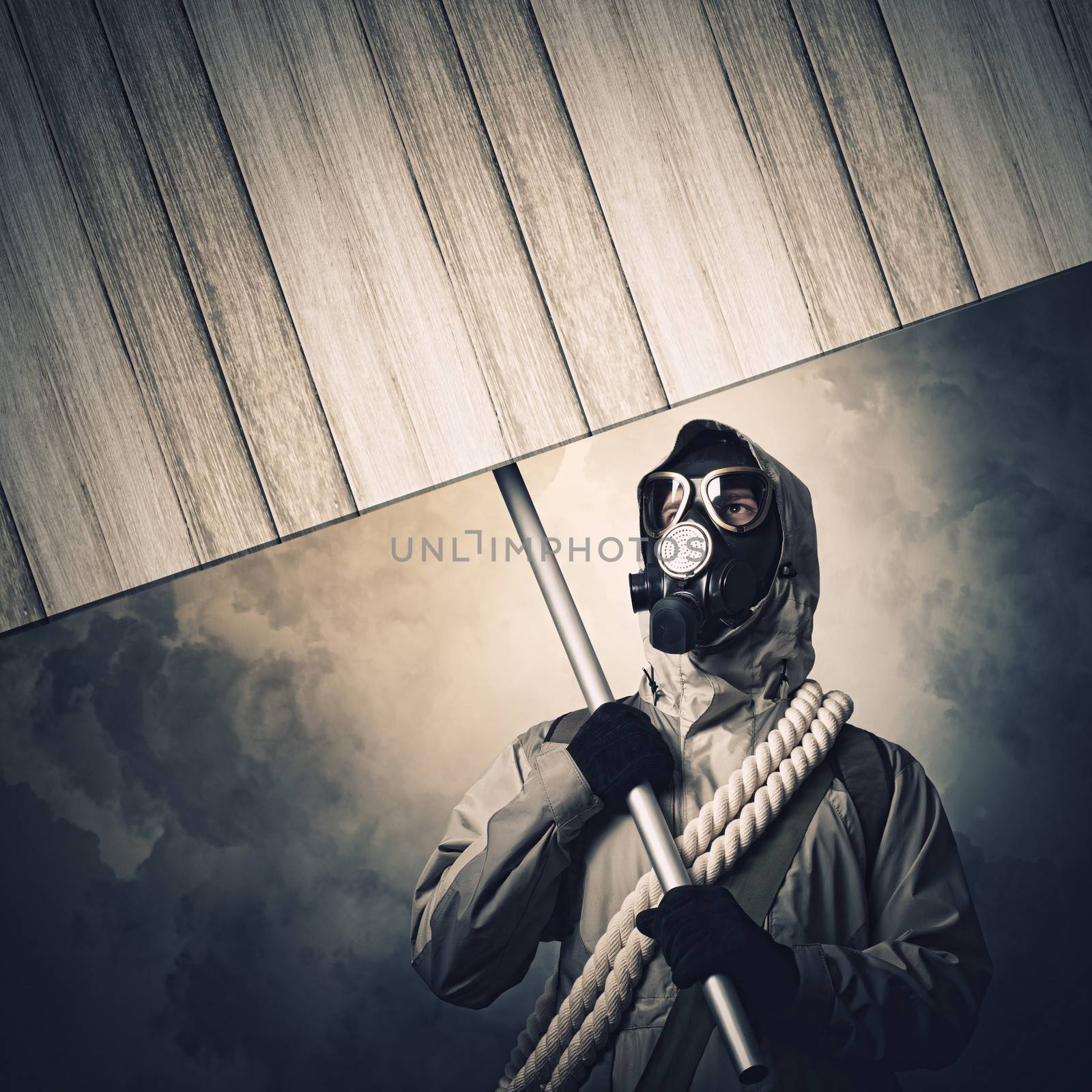 Stalker in gas mask with wooden banner. Disaster concept