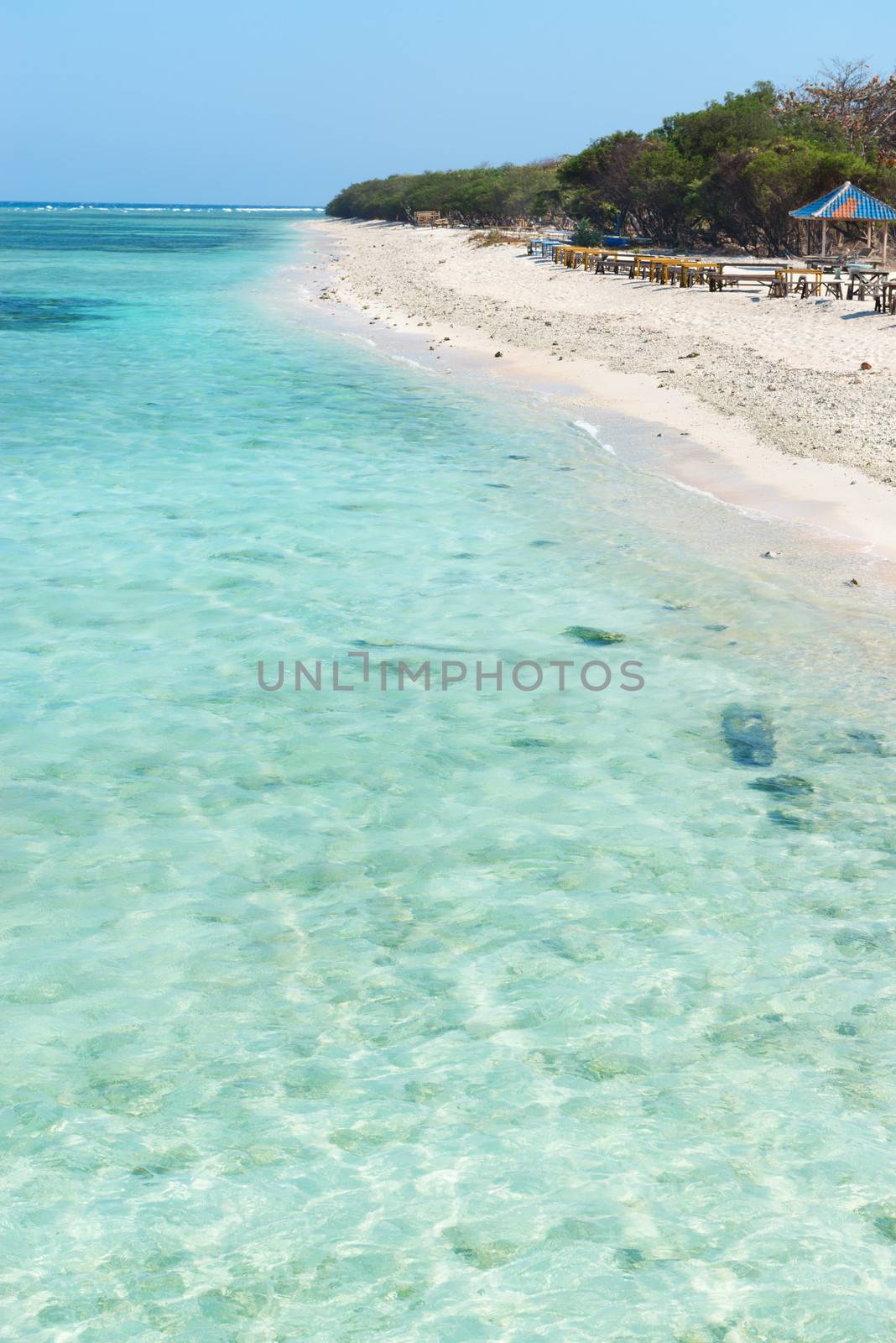 Beautiful beach with blue clean water and seaside cafe on tropical beach. Selective focus on front water.