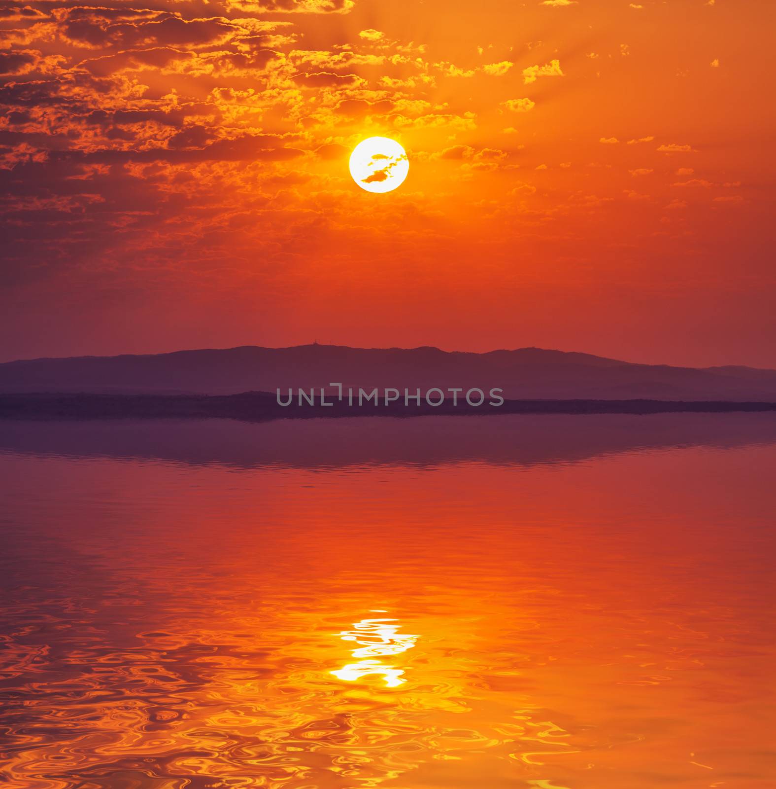 Vibrant rising sun at dawn over water by Discovod