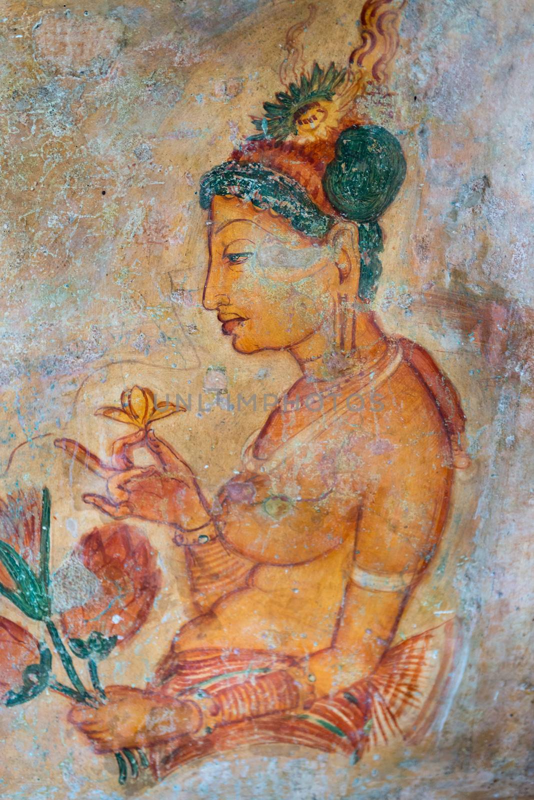 Ancient wall paintings of cloudy maiden with flower. One of the 5th century frescoes at the ancient rock fortress of Sigiriya, Sri Lanka. 