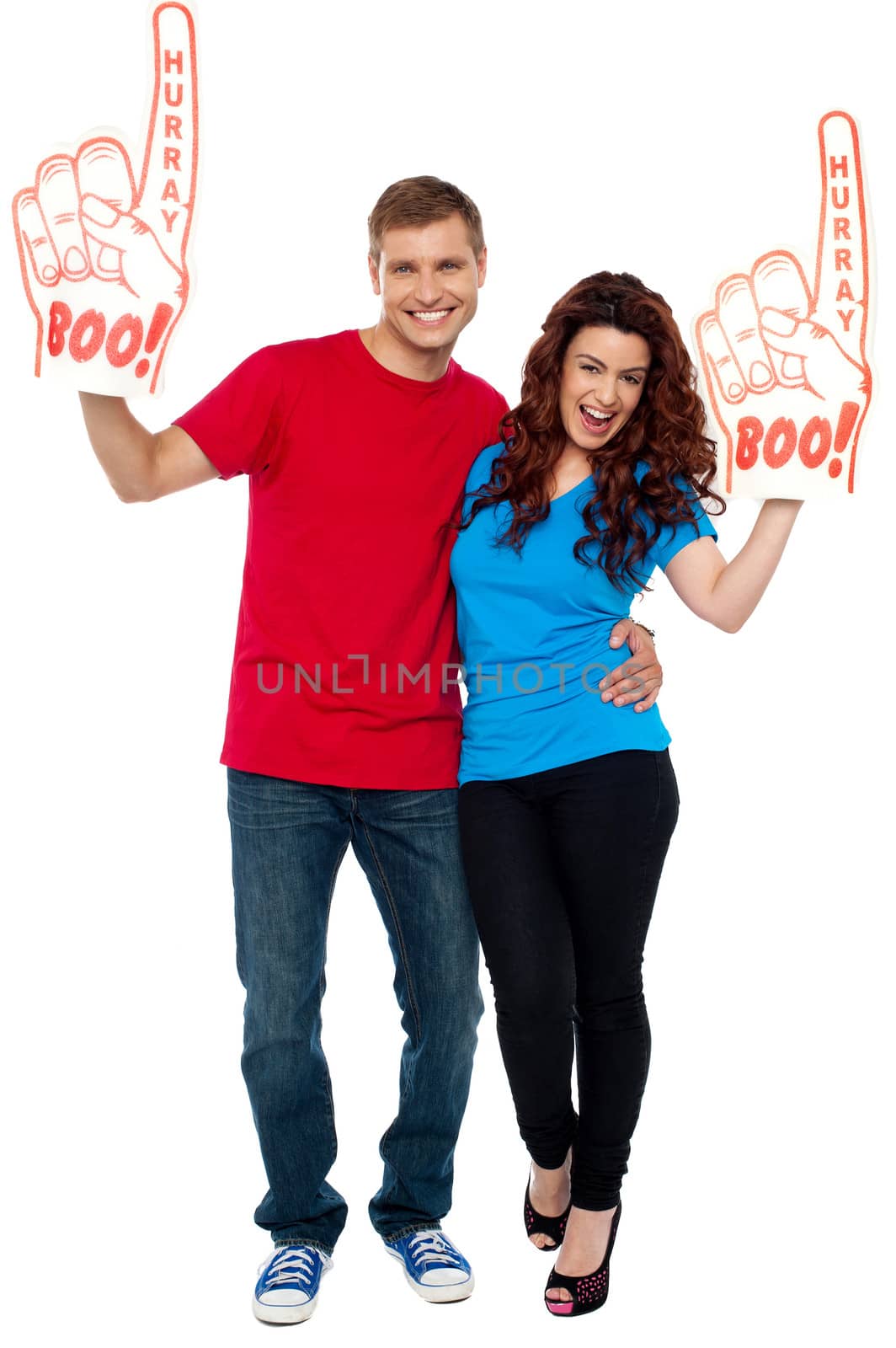 Excite young couple showing boo hurray foam hand and cheering against white background