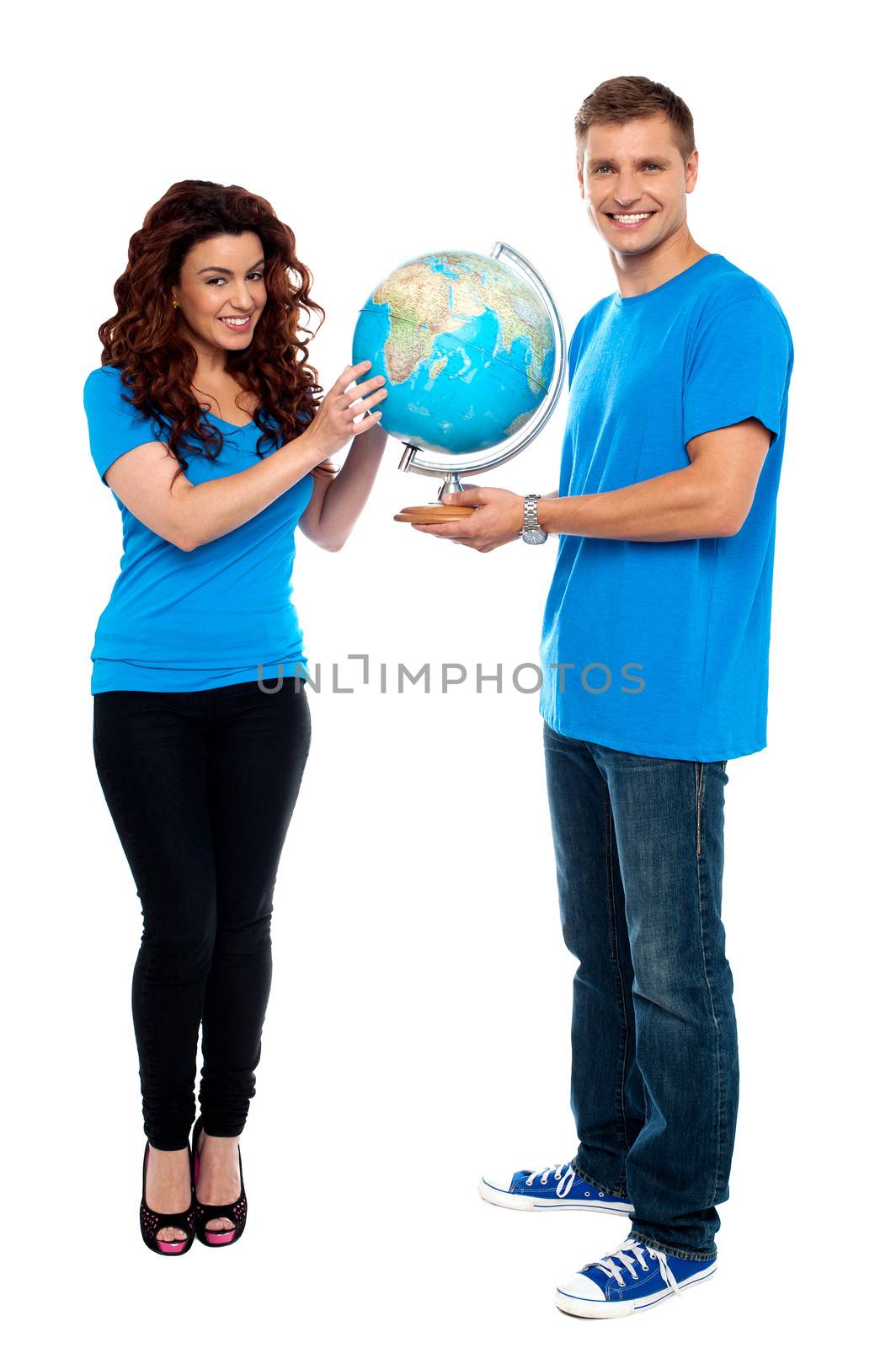 Full length of a couple holding globe over white. Smiling at camera