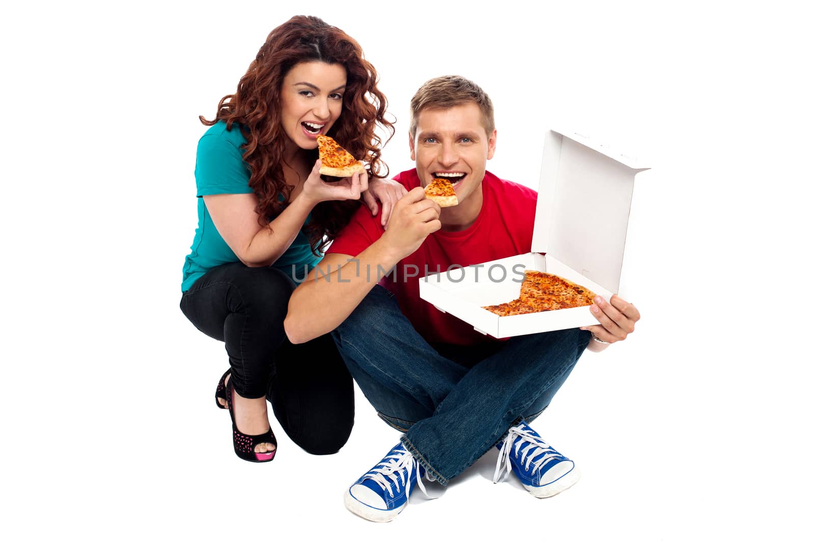 Young couple sitting on floor and enjoying yummy pizza