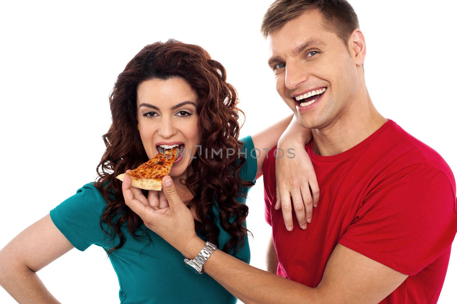 Boyfriend making her girl eat hot pizza piece. Both having fun
