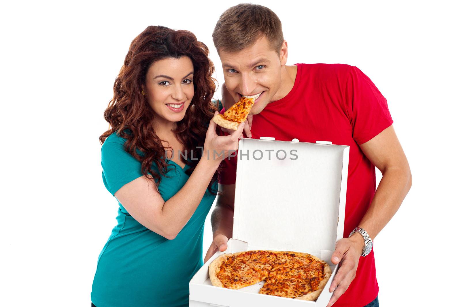 Pretty woman making her boyfriend end pizza piece by stockyimages