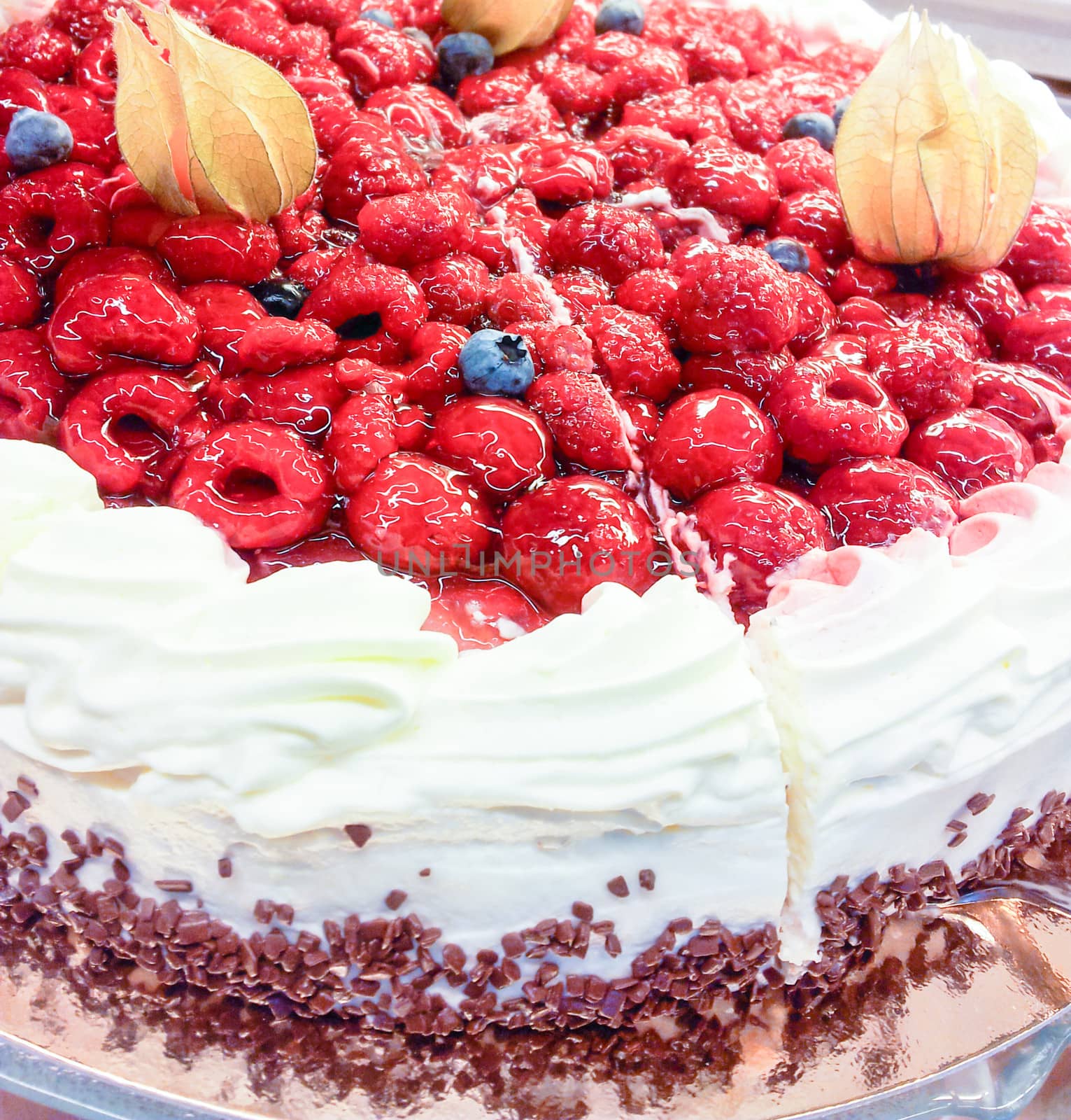 Closeup of a cream cake covered with raspberries and gelatin