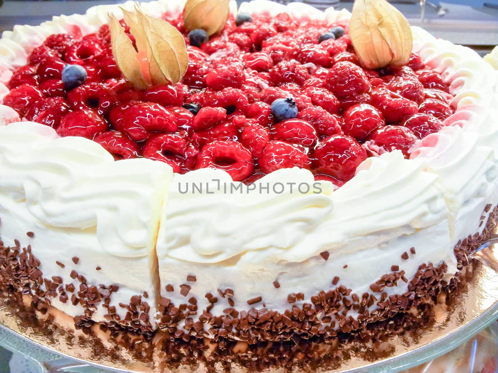 Closeup of a cream cake covered with raspberries and gelatin