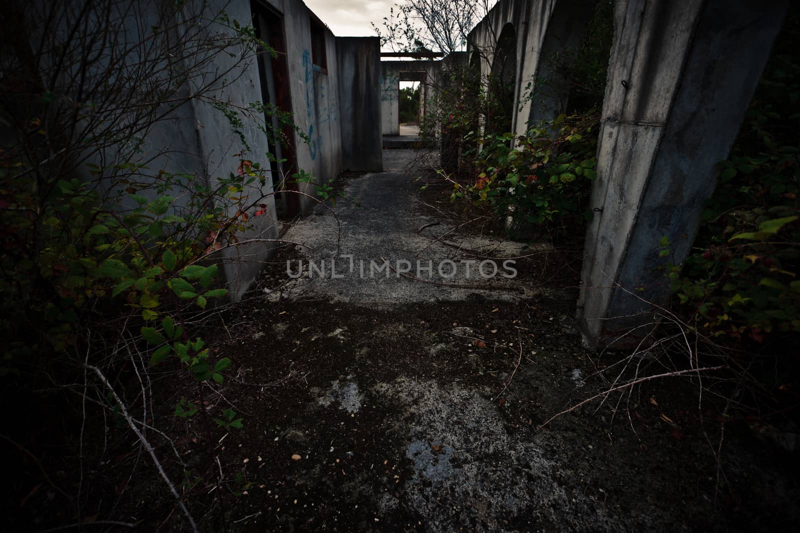 Dark deserted passageway in a derelict abandoned building without a roof for a spooky atmospheric background