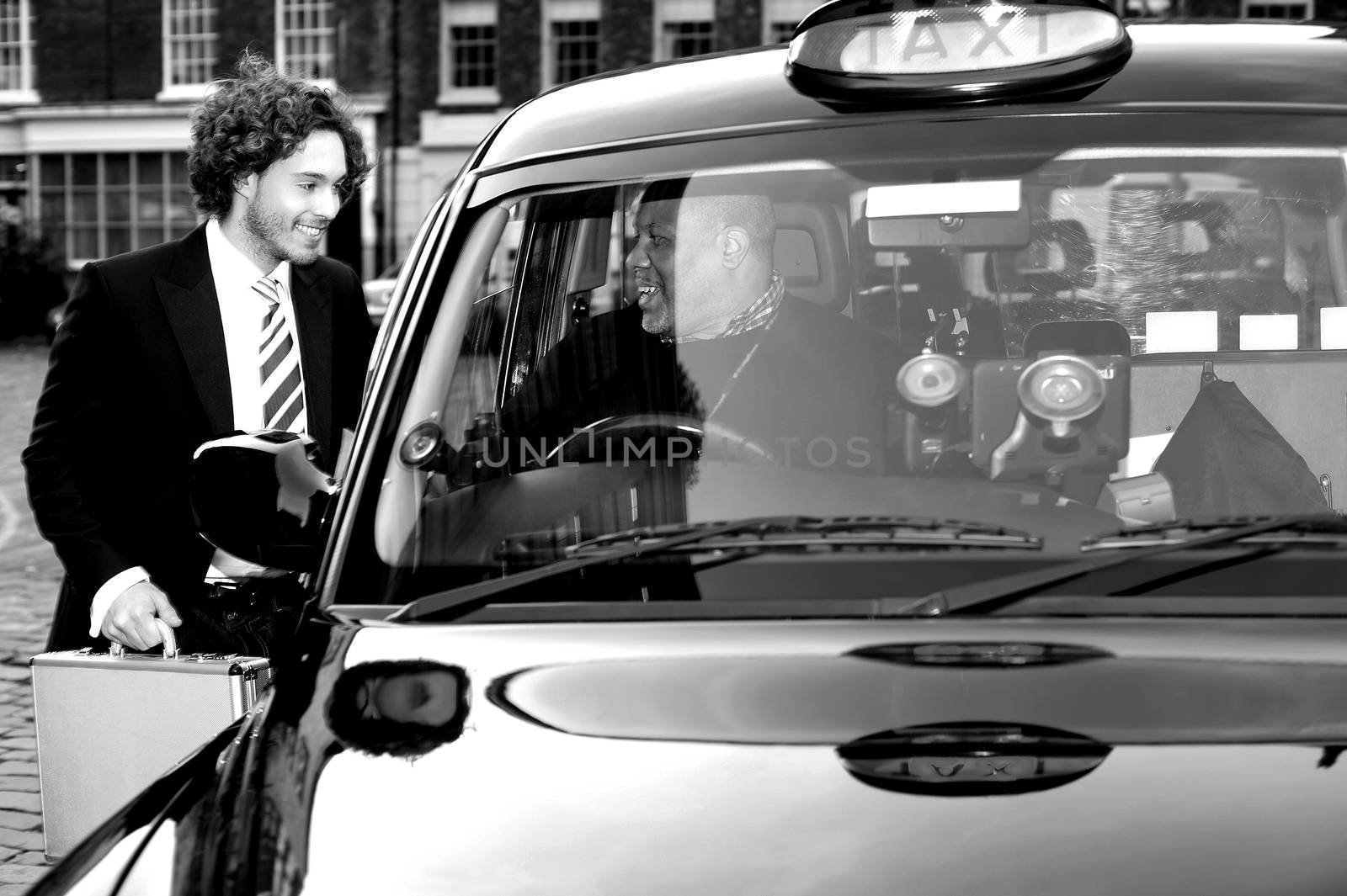 Male passenger communicating with taxi driver by stockyimages