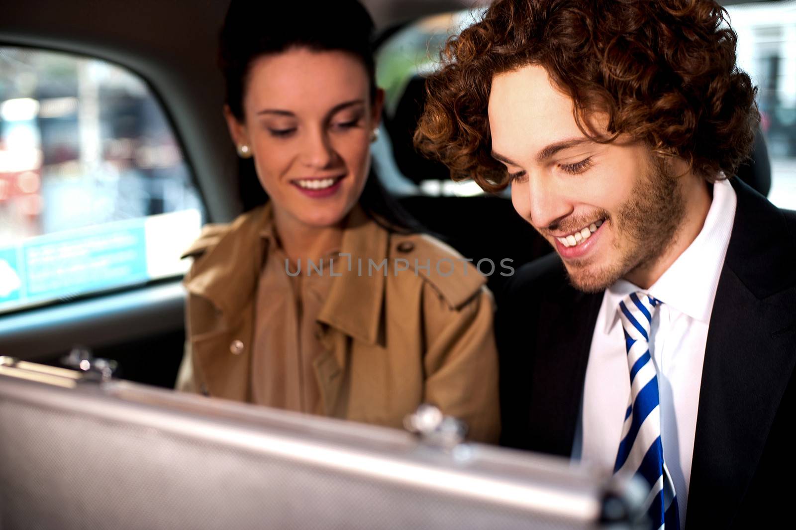 Cheerful business colleagues travelling in a cab.