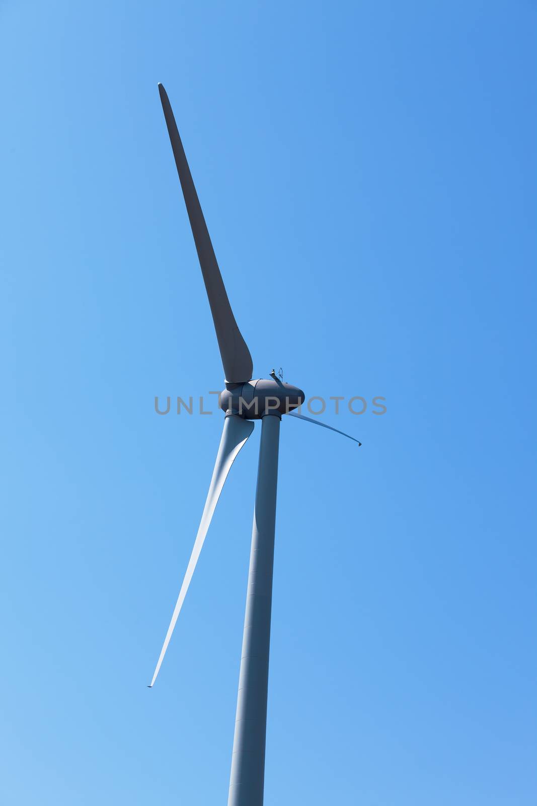 Wind electric generator against blue sky background