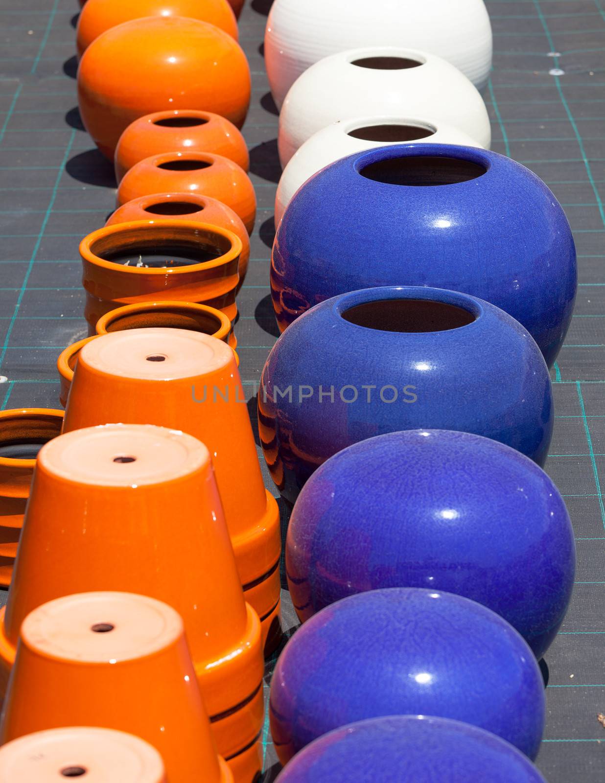 Colorful ceramic pots in market, sunny day