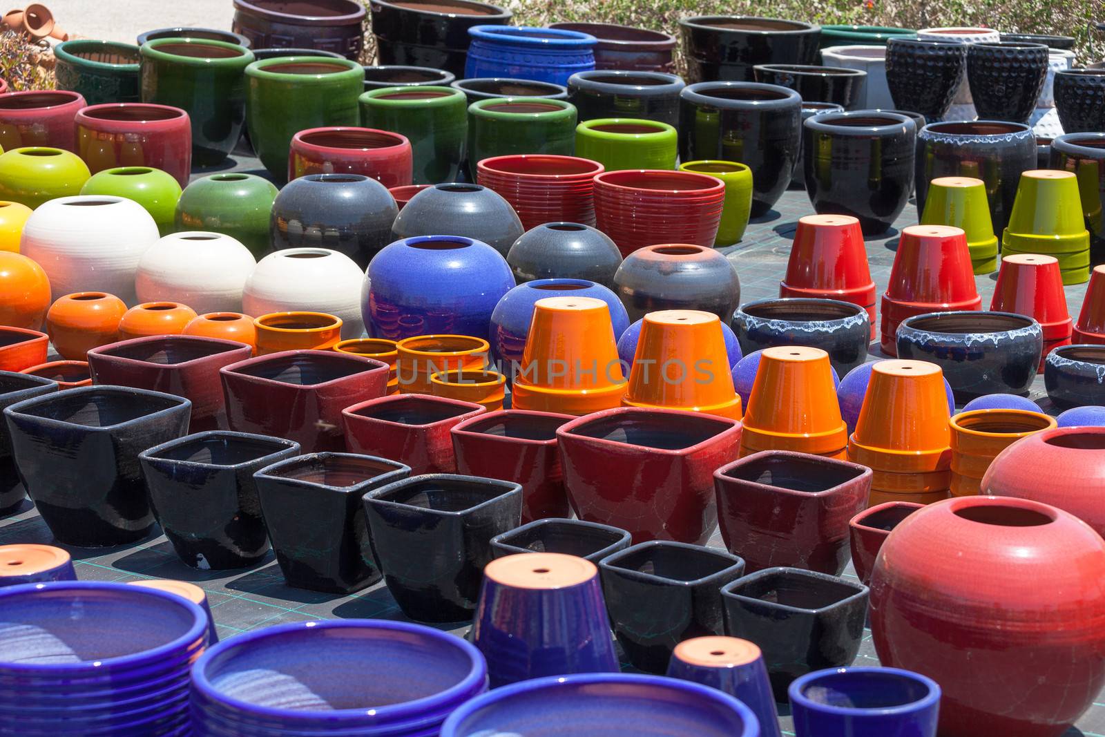 Colorful ceramic pots in market by Discovod
