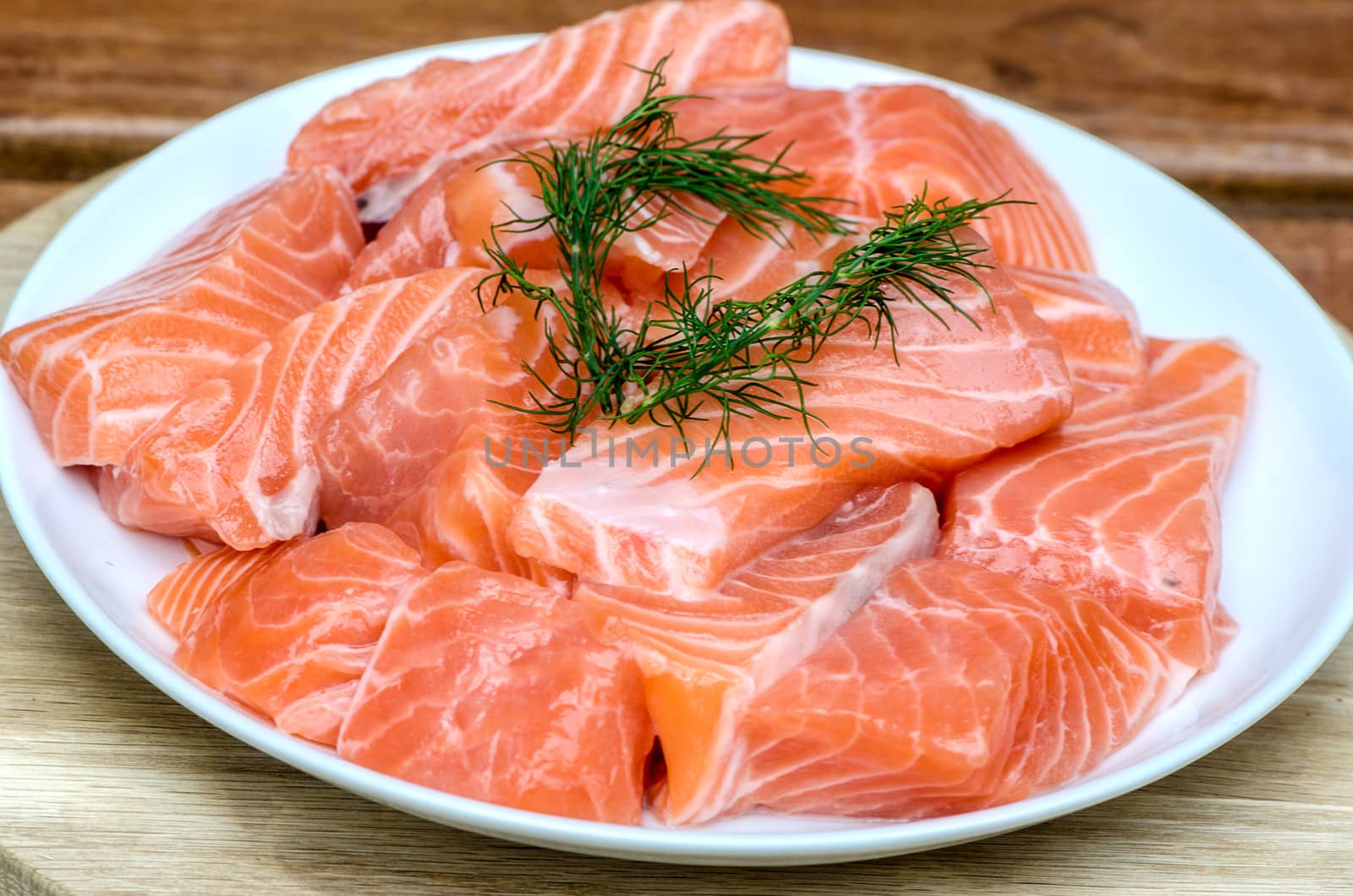 fresh salmon with dill on white plate