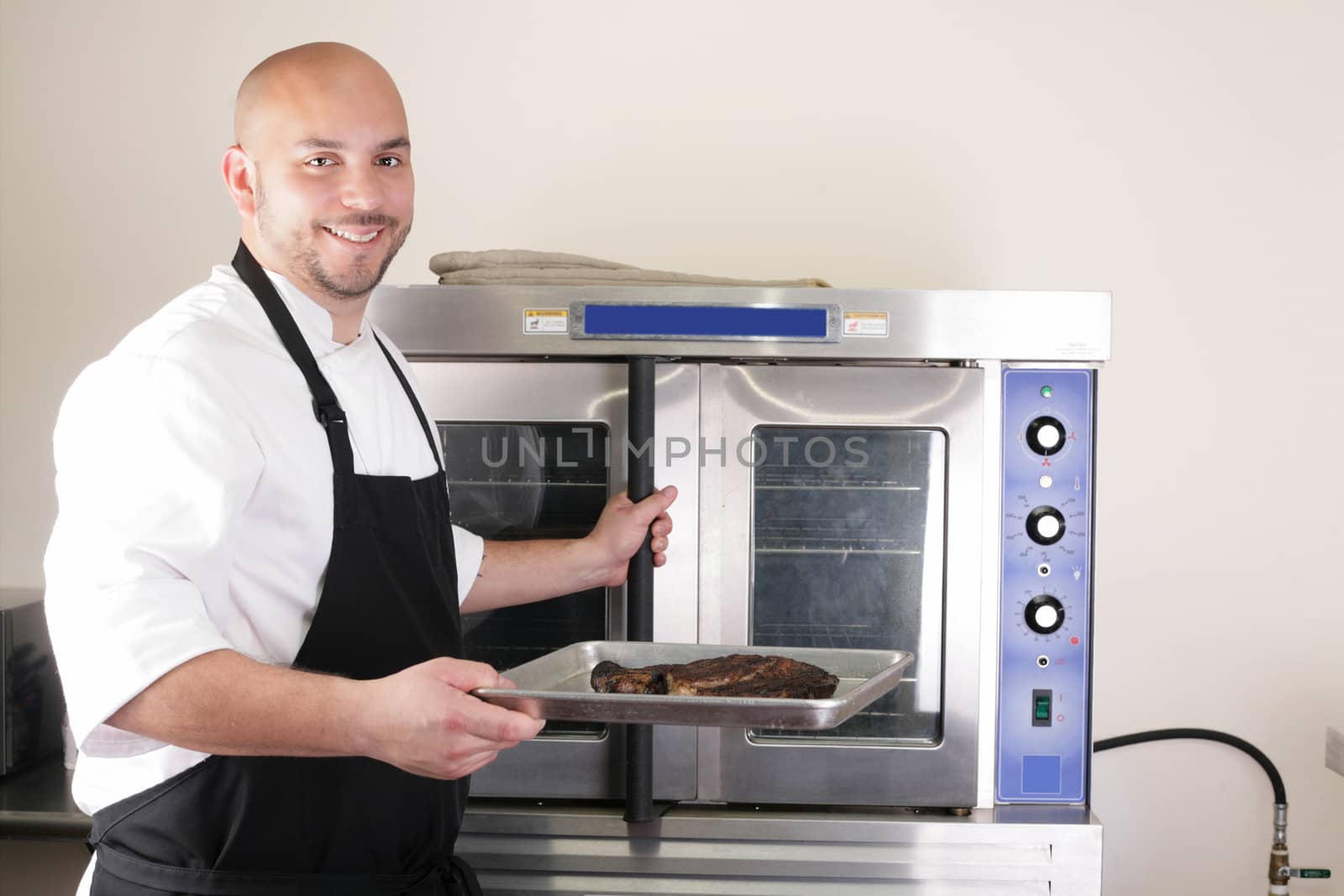 Happy chef taking his freshly baked rib-eye steak by dacasdo