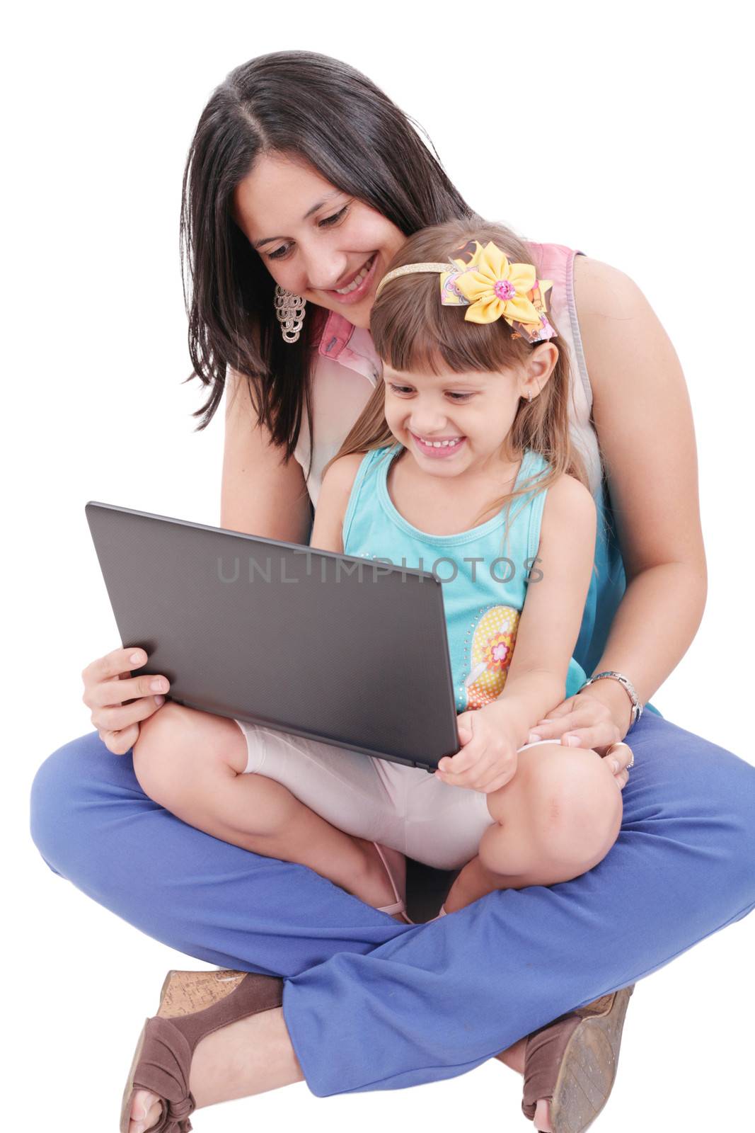 Young mother and daughter looking at laptop. Focus in the mother.